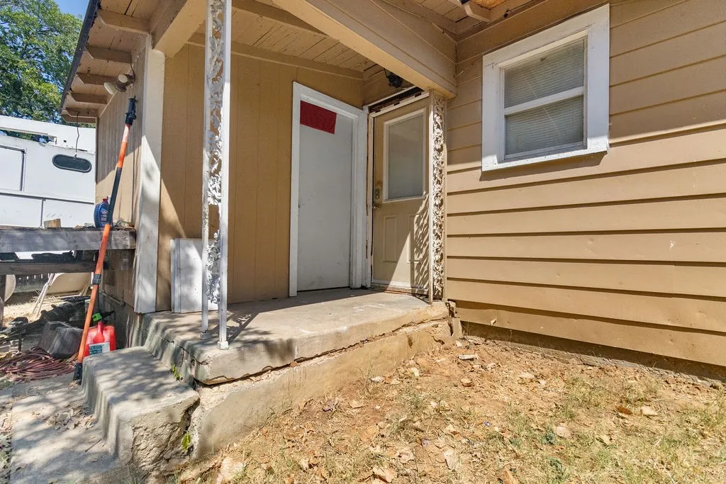 Front entry with concrete steps, decorative metal railing, and horizontal siding
