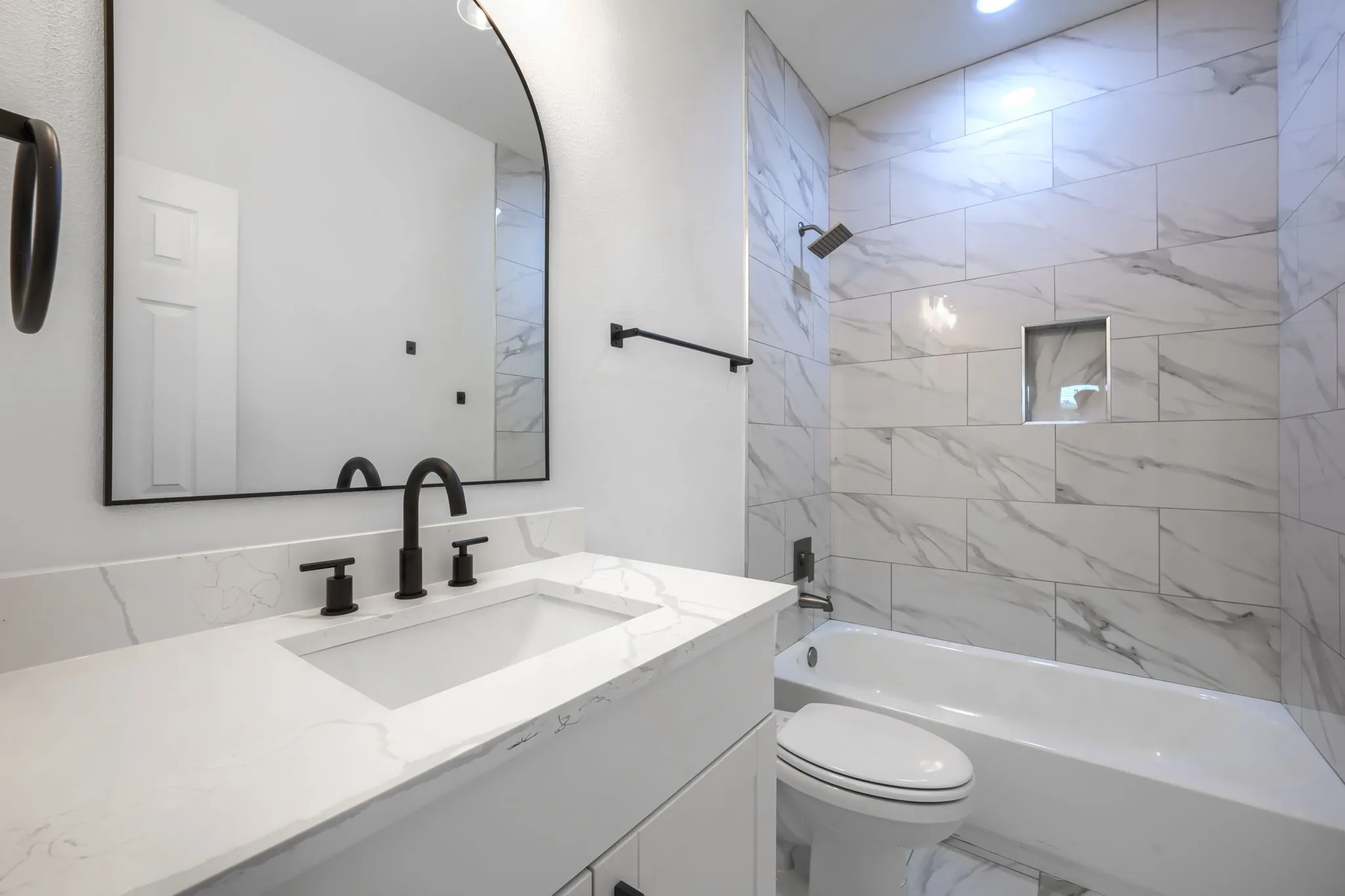 White vanity with an integrated sink and light-toned countertop