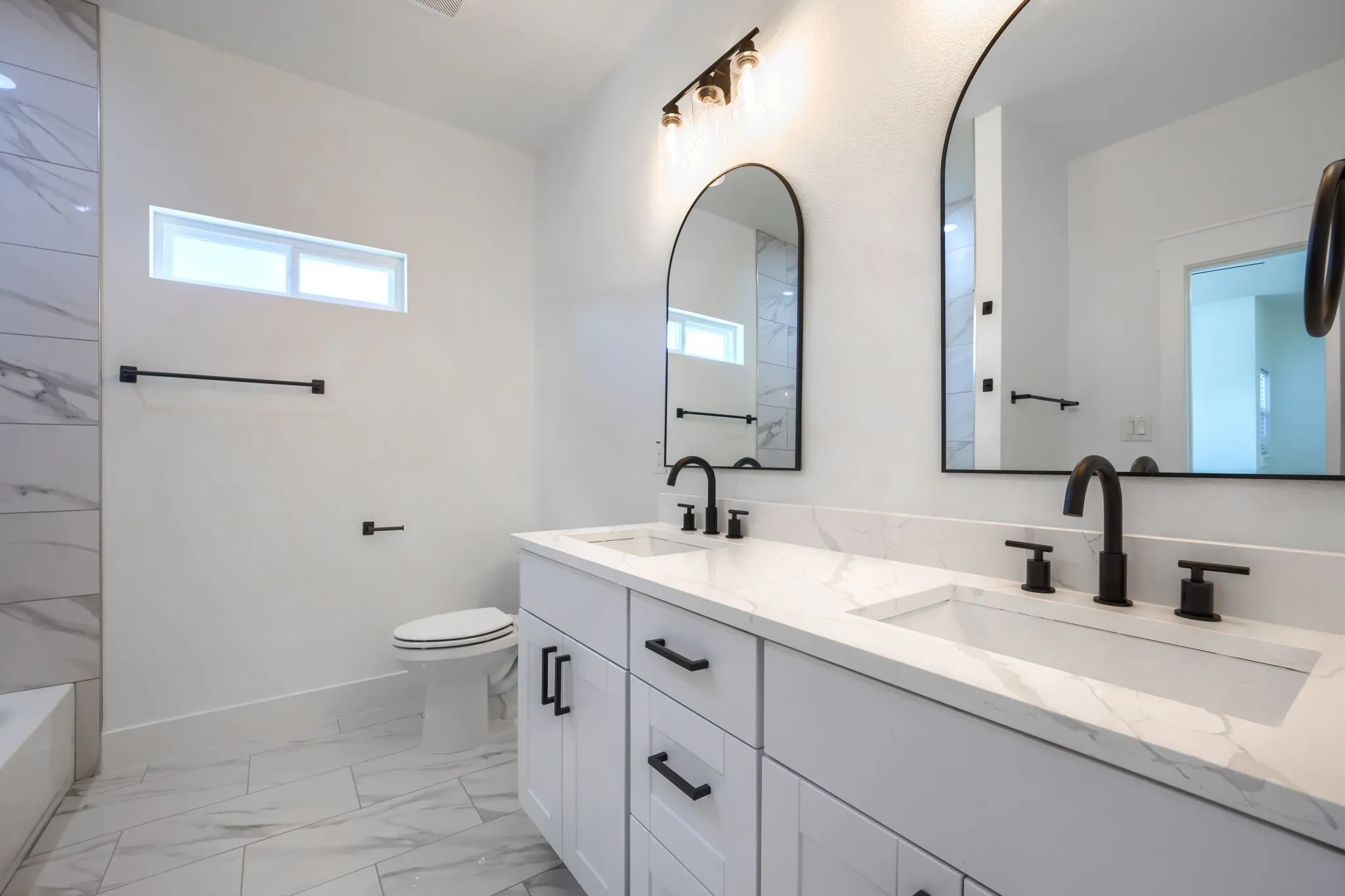 Dual vanity with rectangular undermount sinks, stone-finish countertop, and matte black fixtures