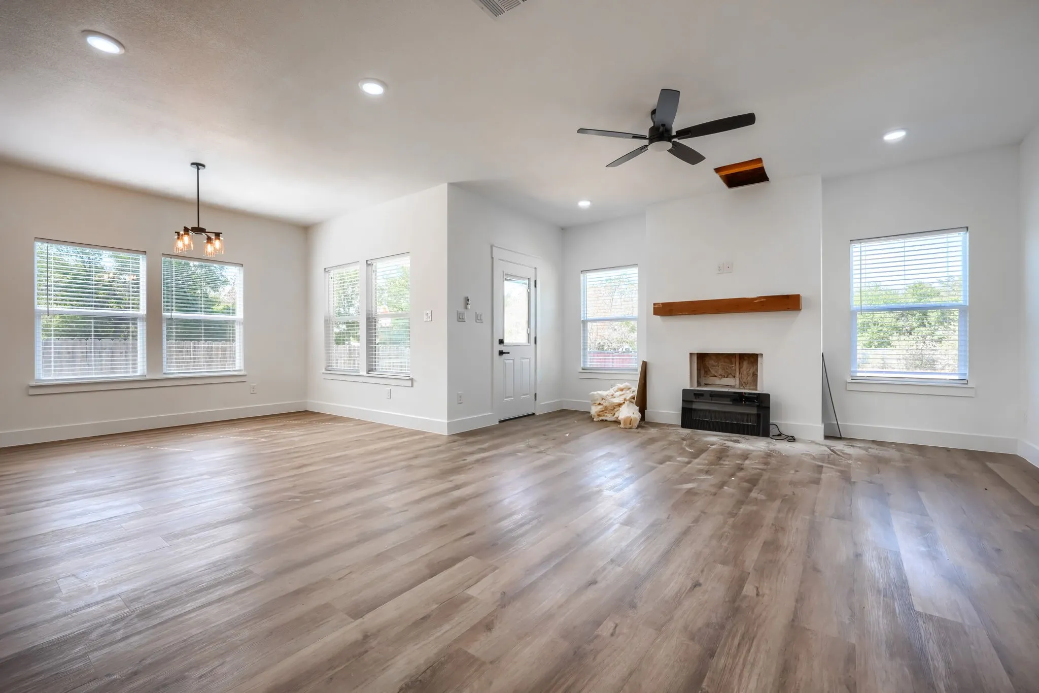 Wood-finish flooring throughout, recessed lighting, and multiple windows with blinds