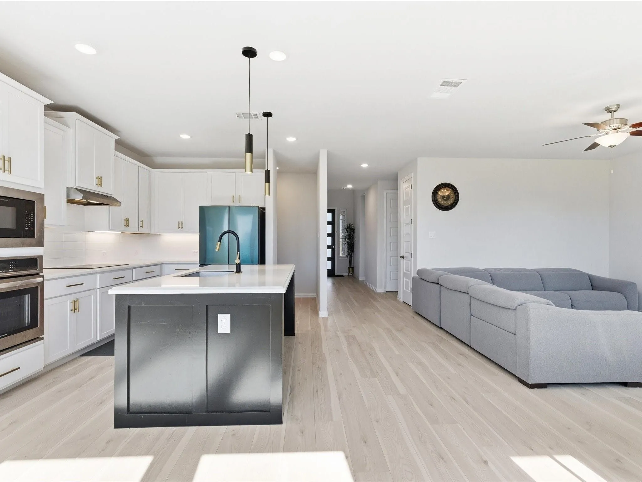 Open-concept living space with light wood-finish flooring