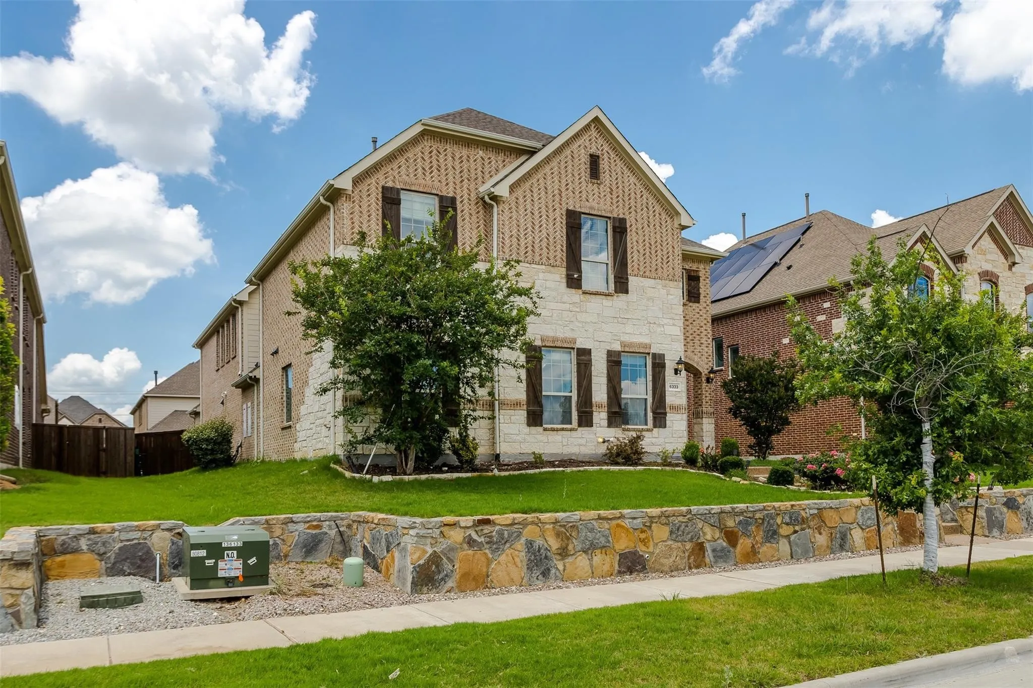 Two-story residence featuring a combination brick and stone exterior