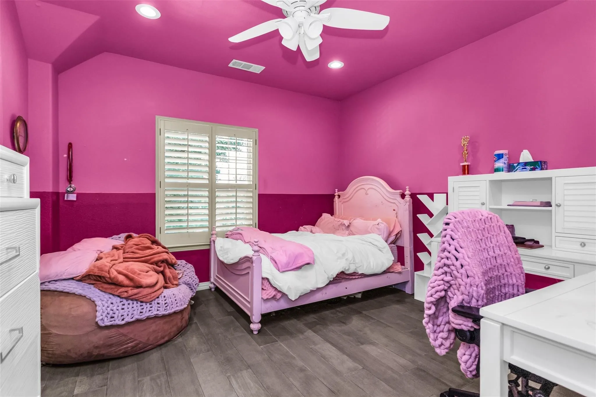 Wood-finish flooring with a durable surface, recessed ceiling lighting, and a ceiling fan with integrated lighting
