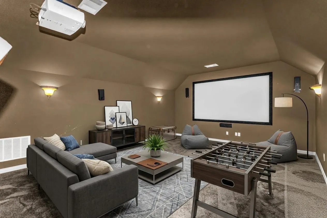 Sloped ceiling room featuring a ceiling-mounted projector, wall sconces, a large projection screen, and geometric pattern carpeting