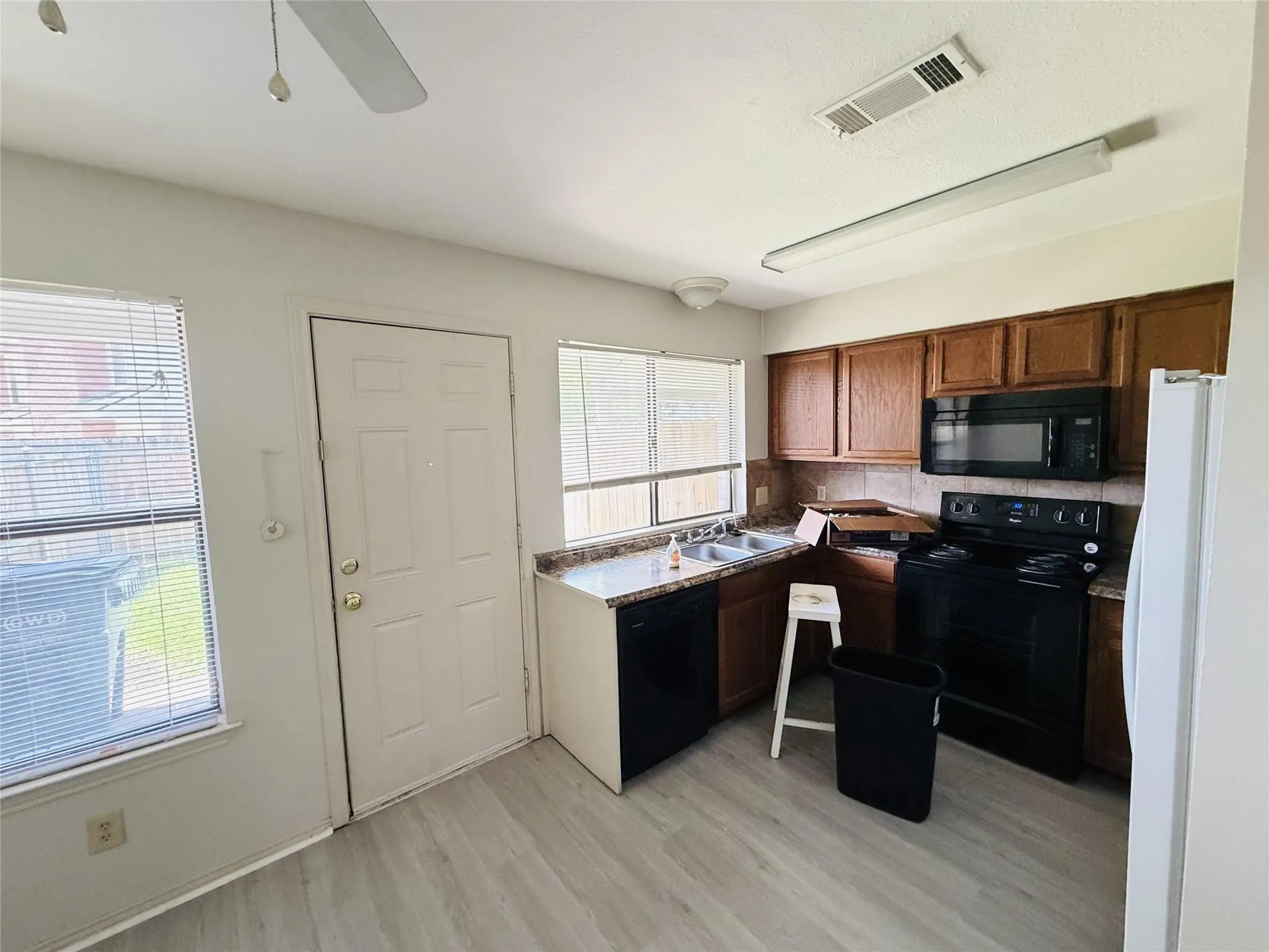 Kitchen with wood-finish flooring, dark wood cabinetry, and a double basin sink