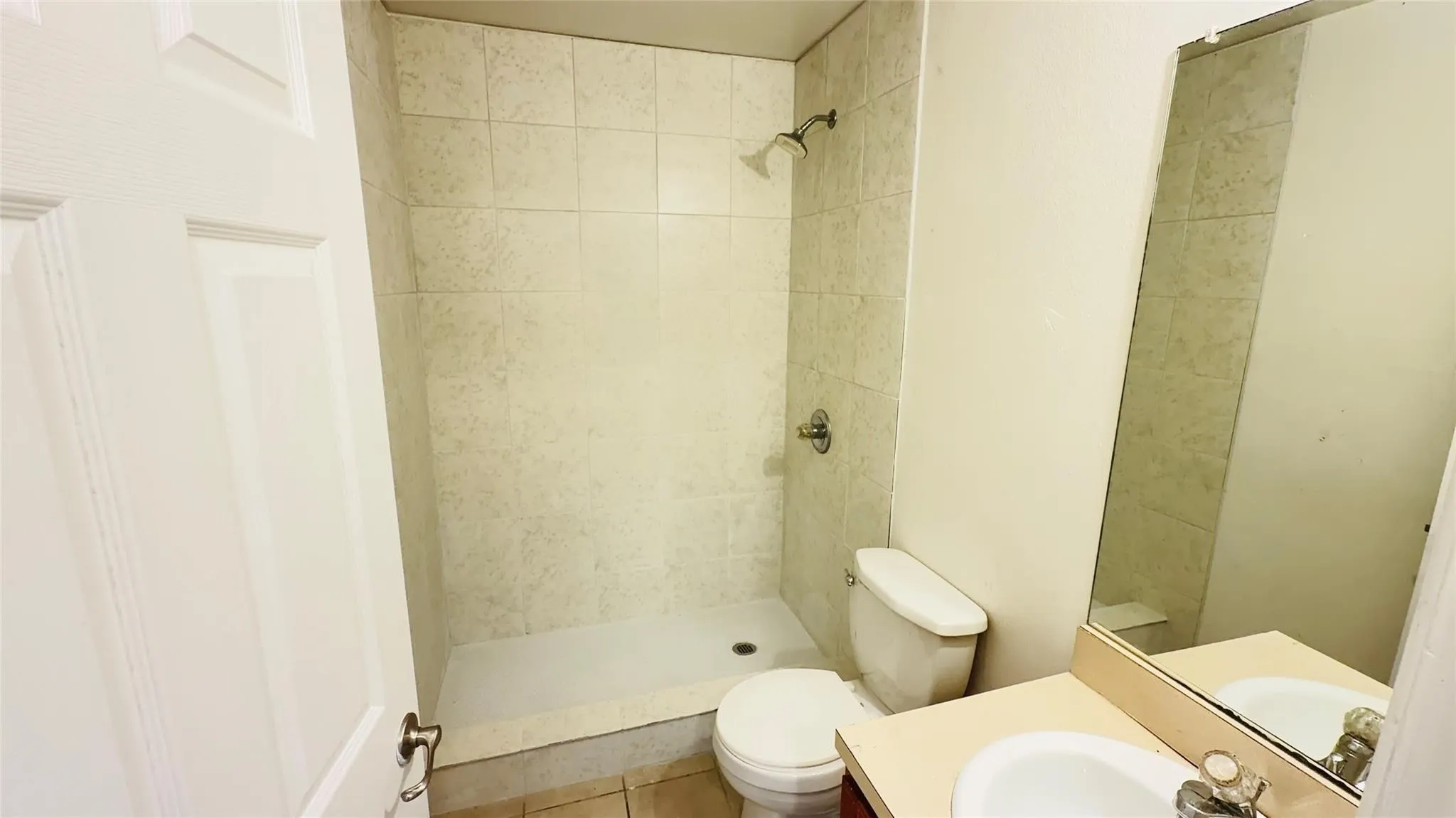 Shower with light-toned wall tiling and a chrome showerhead