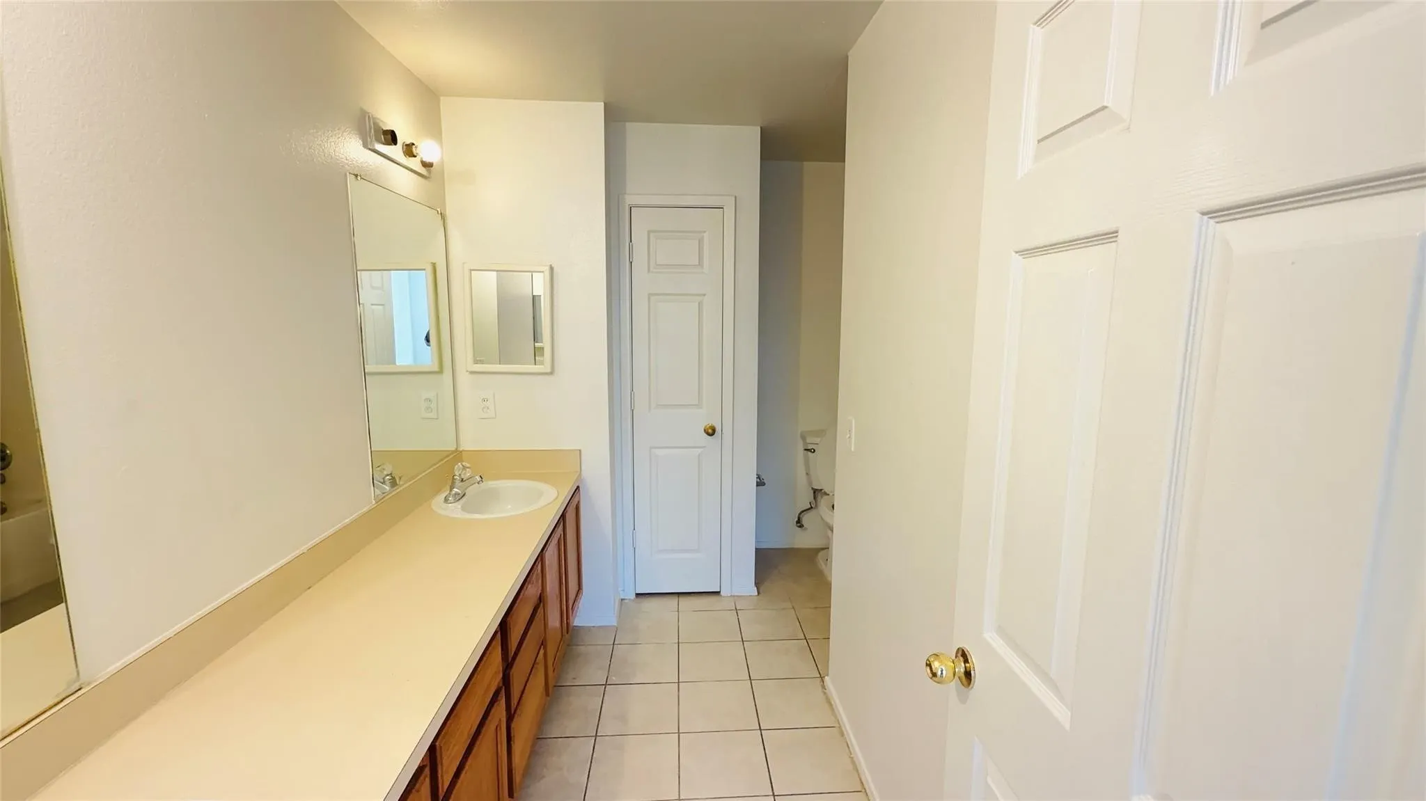 Extended vanity with an integrated sink and wood-finish cabinetry