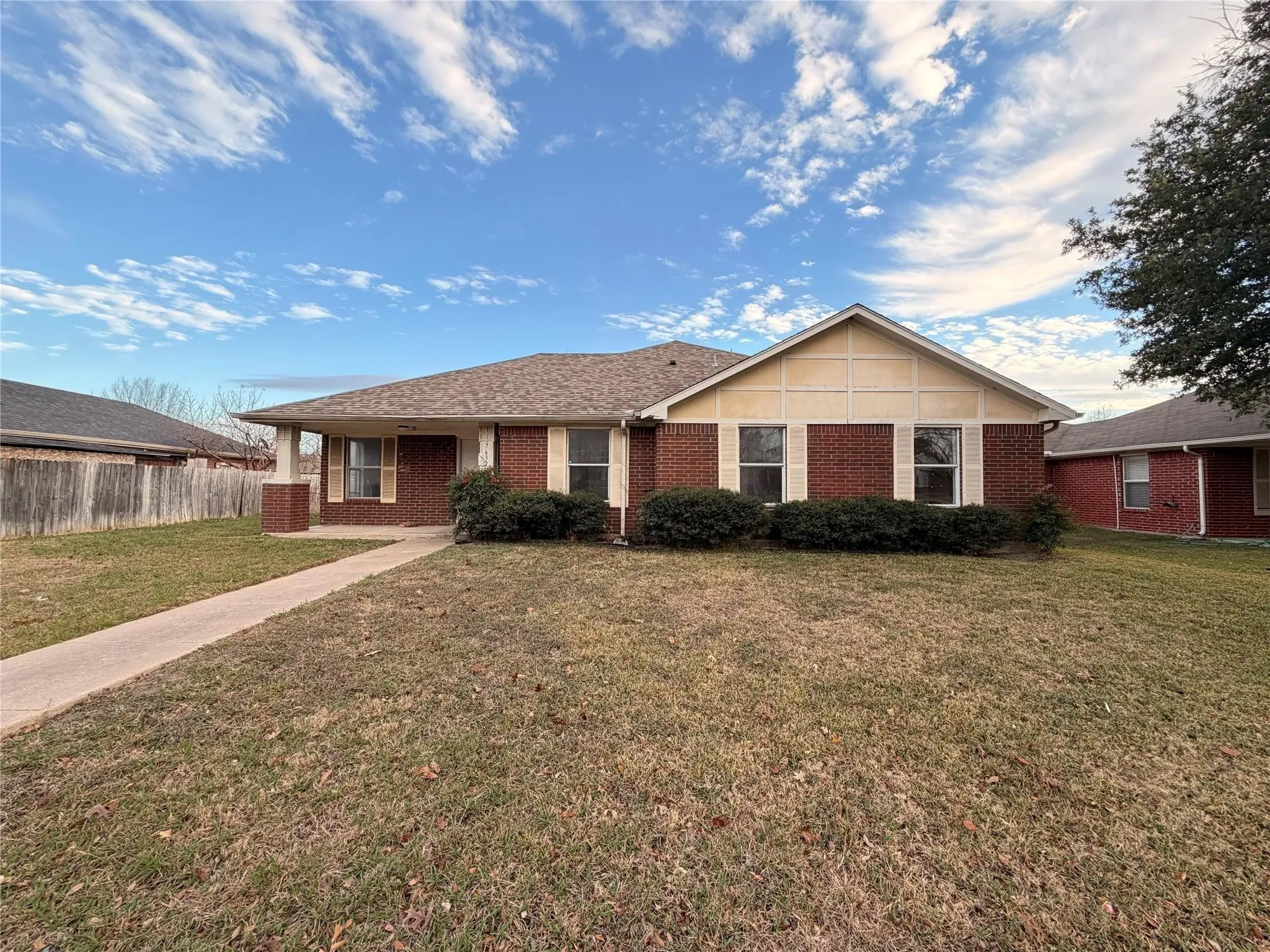 Brick exterior with decorative shutters and a gabled roofline