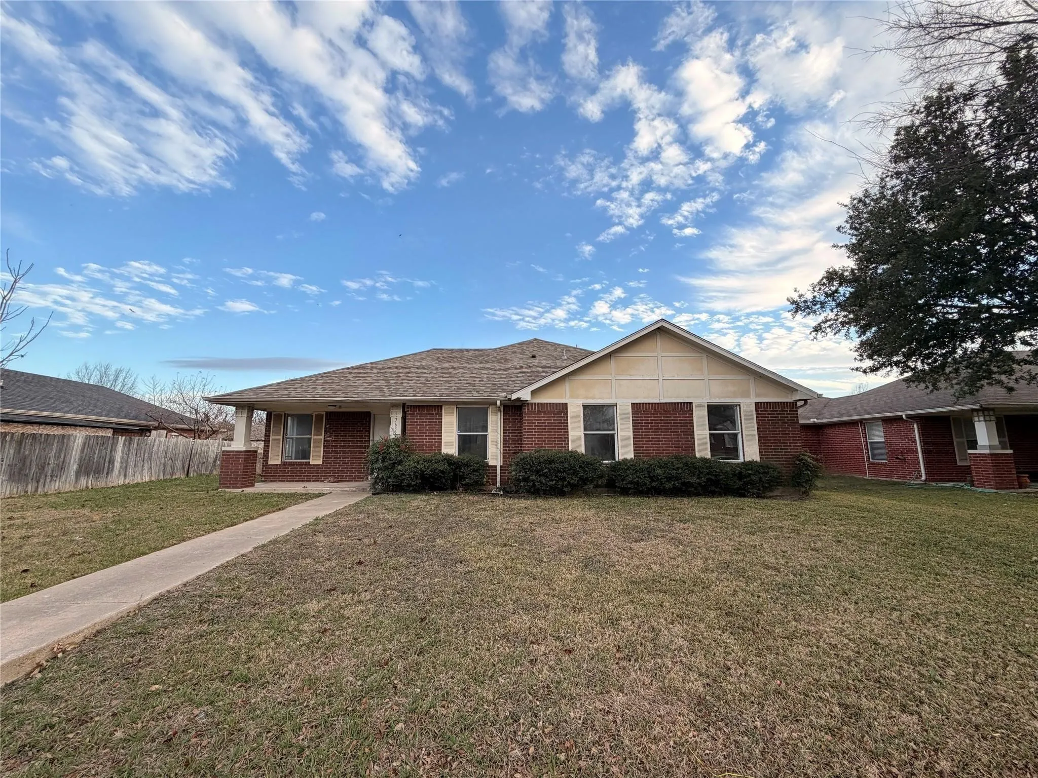 Brick exterior with a gabled roof and covered entry