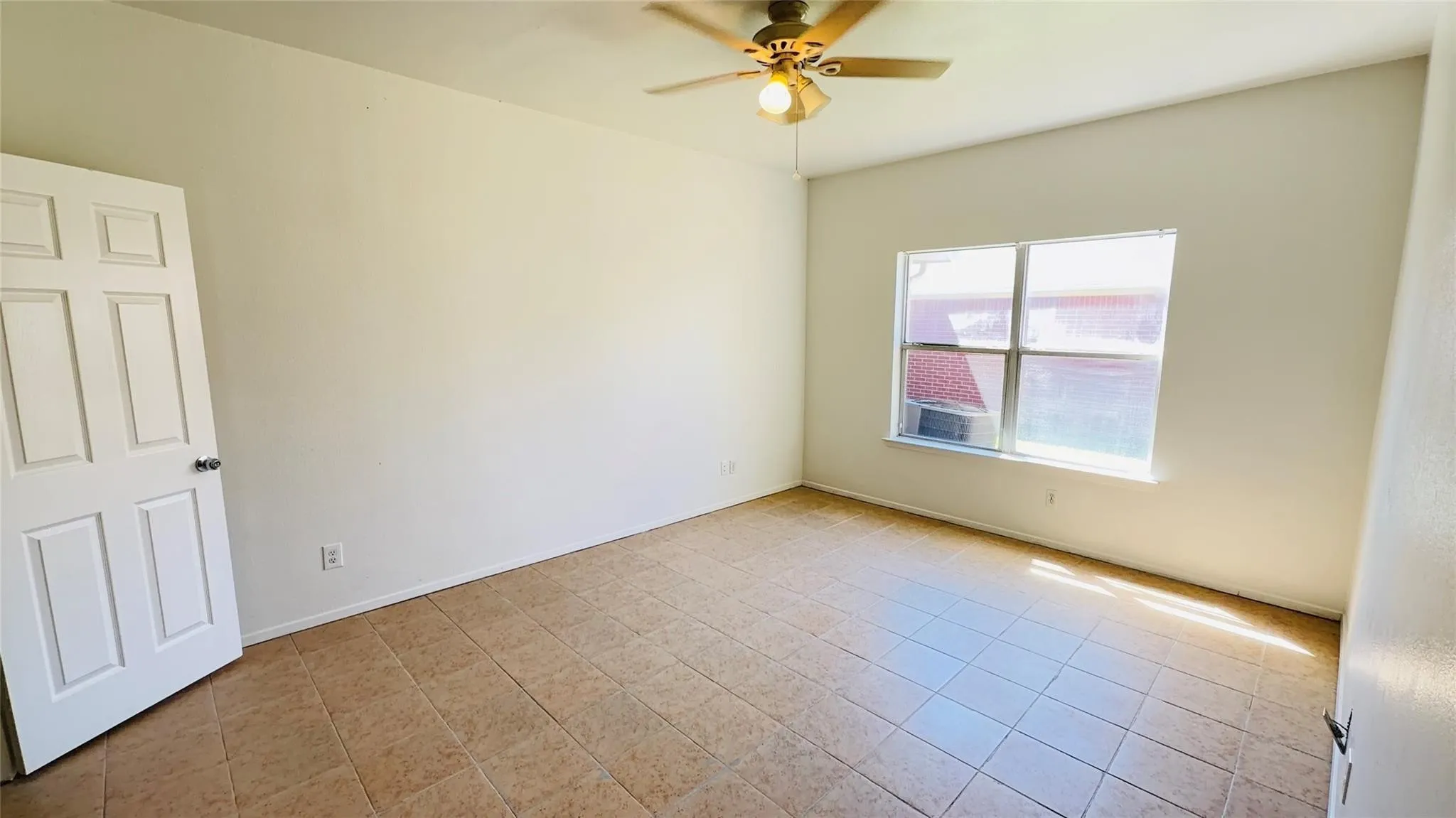 Neutral wall paint, tiled flooring, single window, and a ceiling fan with integrated lighting
