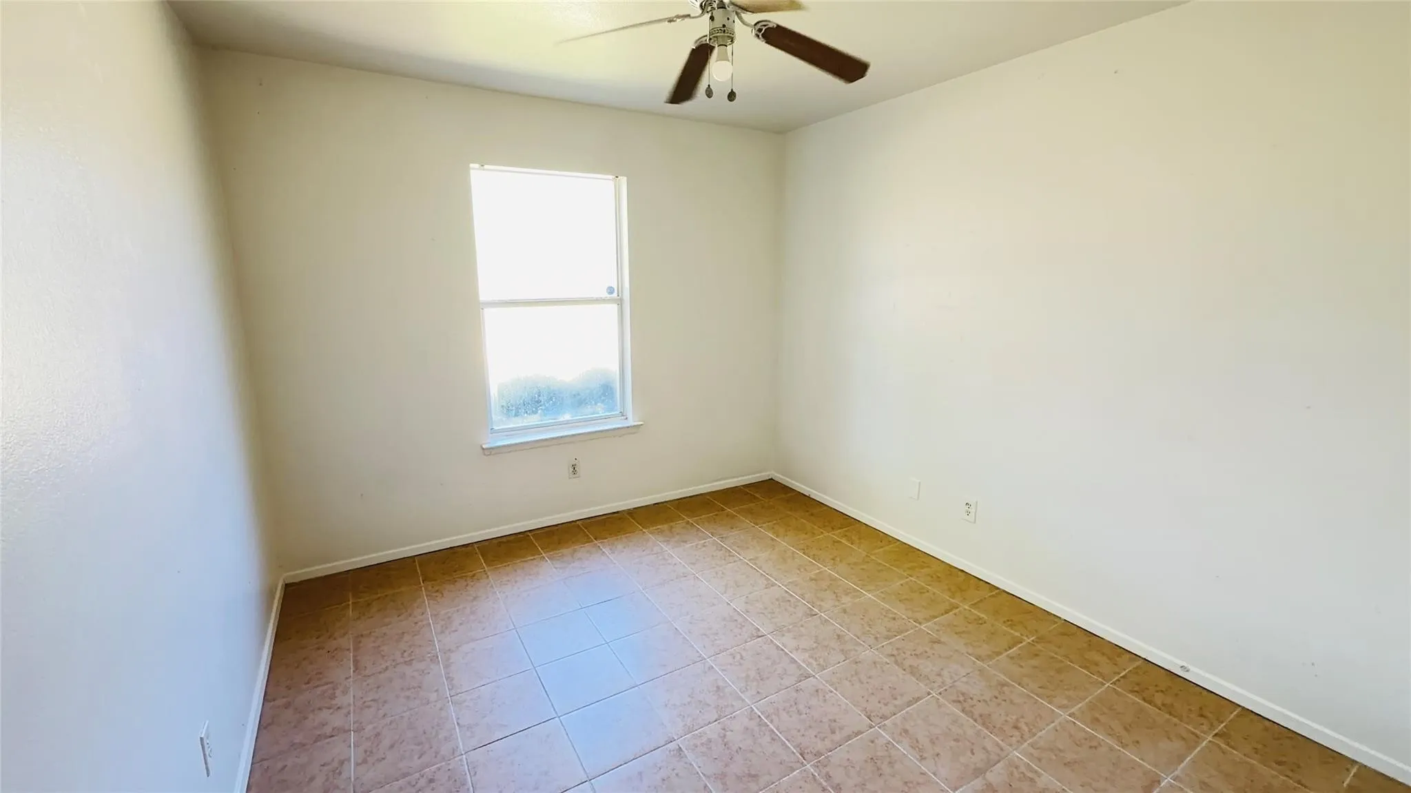 Recessed window with white trim, ceiling fan with light fixture, and tile flooring