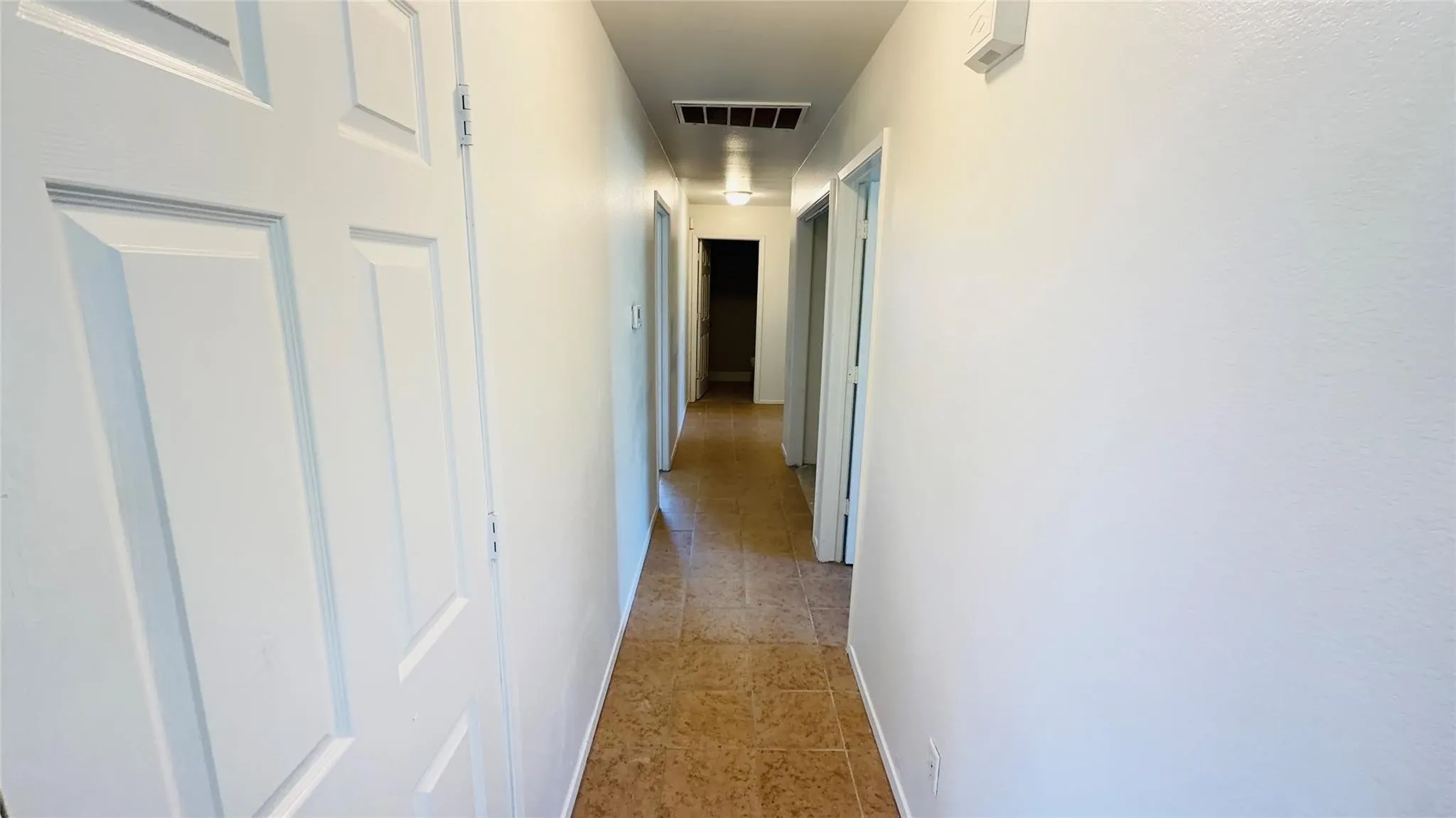 White interior walls and trim, recessed ceiling lighting, and tiled flooring