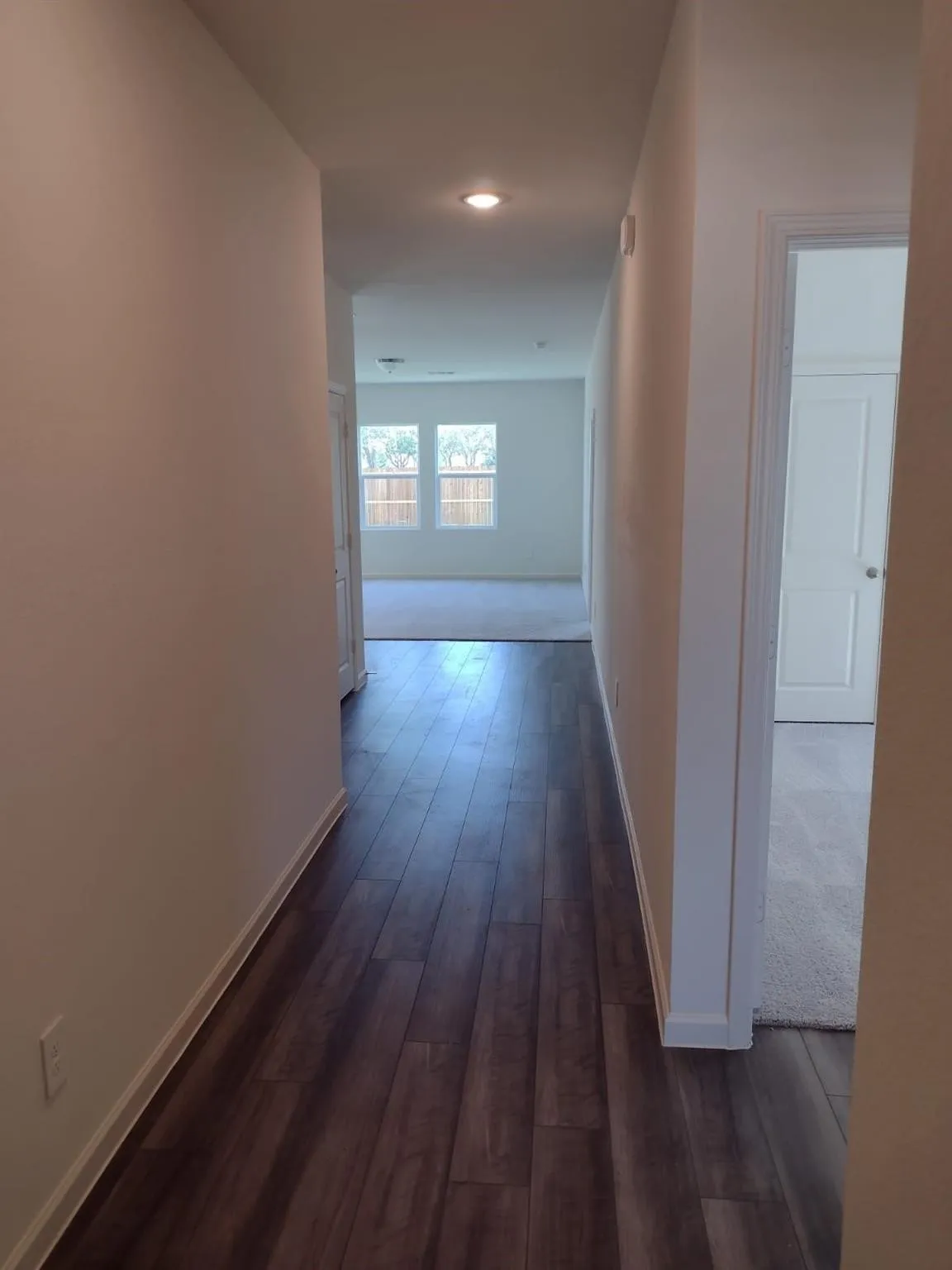 Hallway featuring wood-finish flooring, recessed lighting, and neutral wall paint