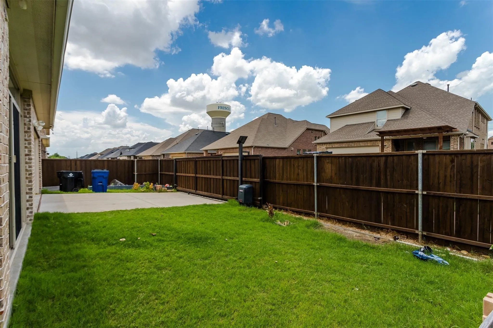 Private backyard space featuring a green lawn, concrete patio, and wood privacy fencing