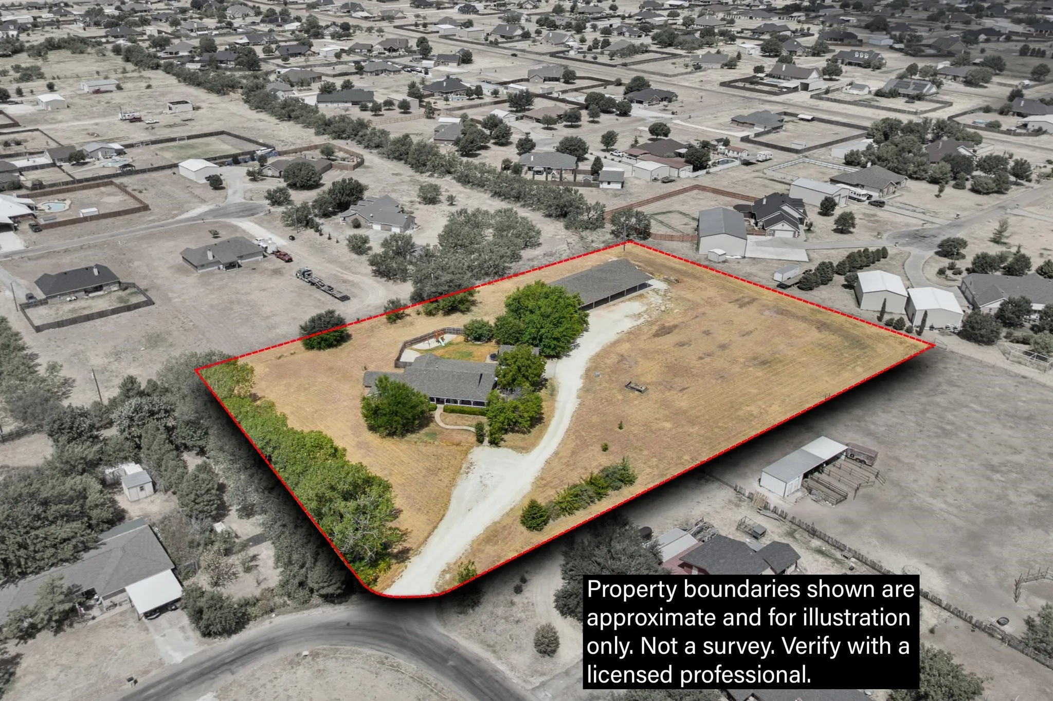 Expansive property featuring a central residence, a large outbuilding, mature trees, and a substantial unpaved driveway