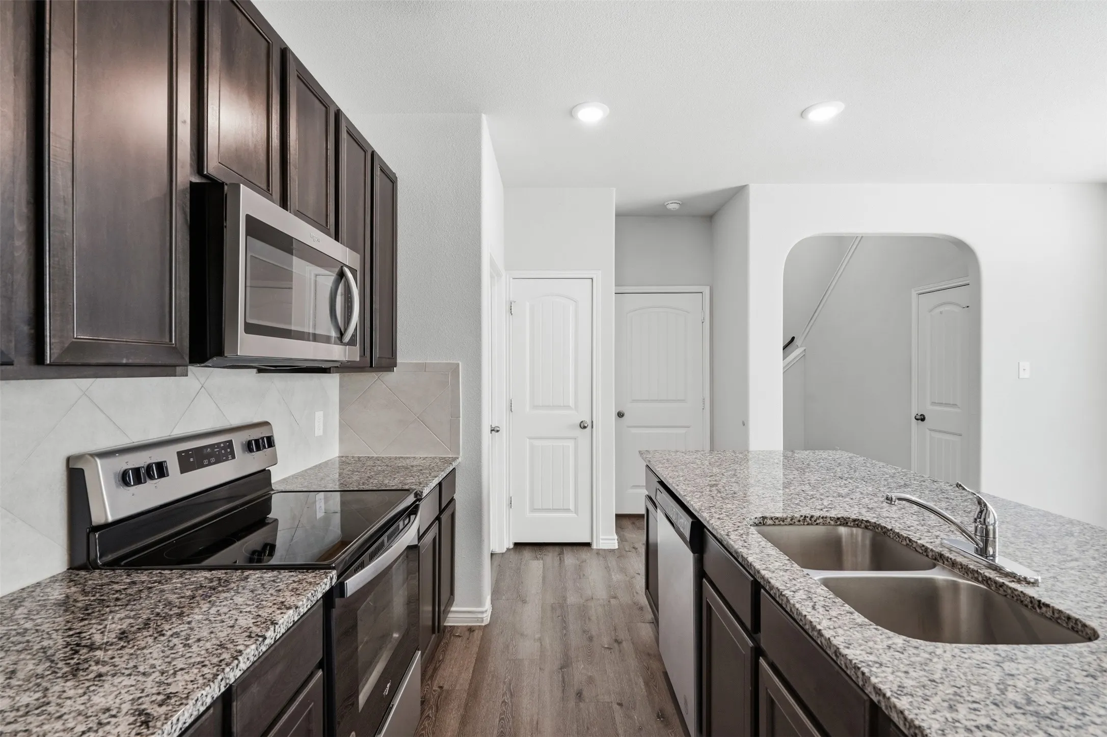 Undermount sink, granite counters, stainless electric range in kitchen at 8020 Flora Drive listed  by Seth Fowler of Williams Trew Real Estate