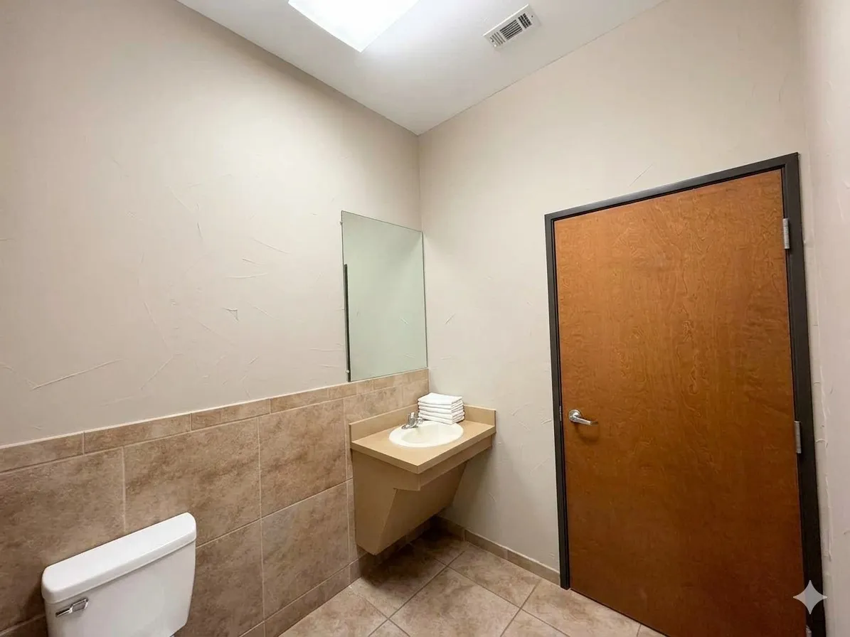 Recessed ceiling lighting, wall-mounted mirror, ceramic tile flooring, and a wall-mounted vanity with integrated sink