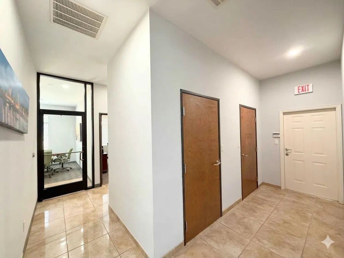 Recessed ceiling lighting, tiled flooring, glass-paneled office entrance, wood-finish doors, and white paneled door