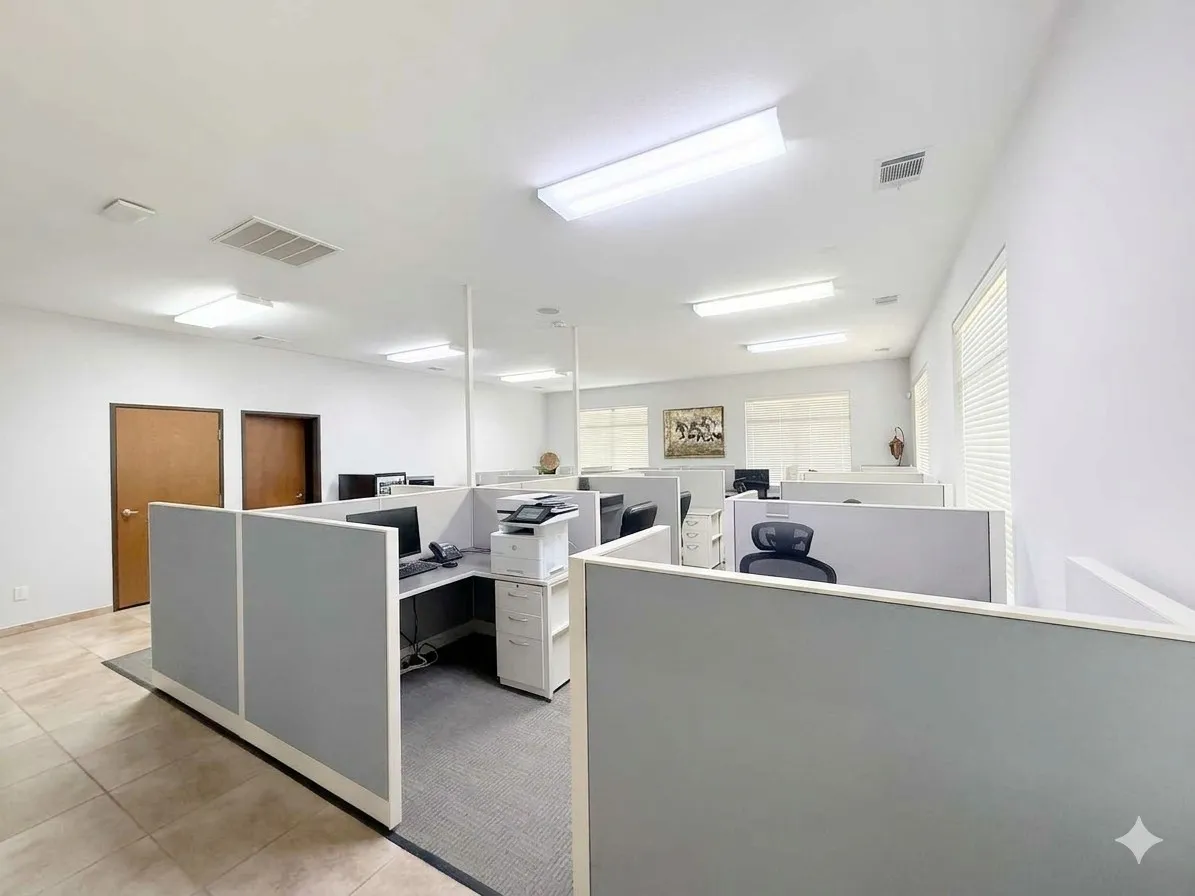 Open-concept office space with white walls and a light-toned tile floor