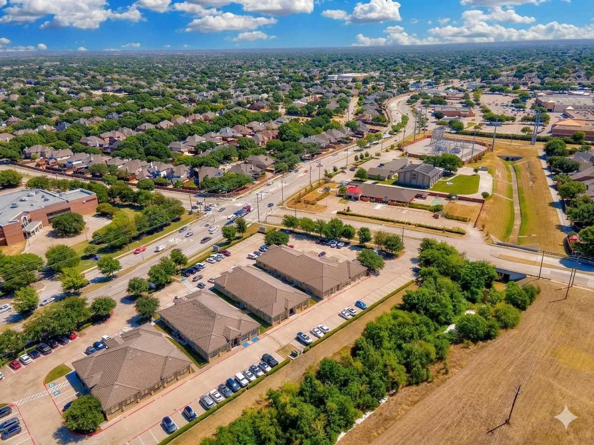 Expansive aerial view of a suburban area featuring residential neighborhoods, commercial buildings, and mature landscaping