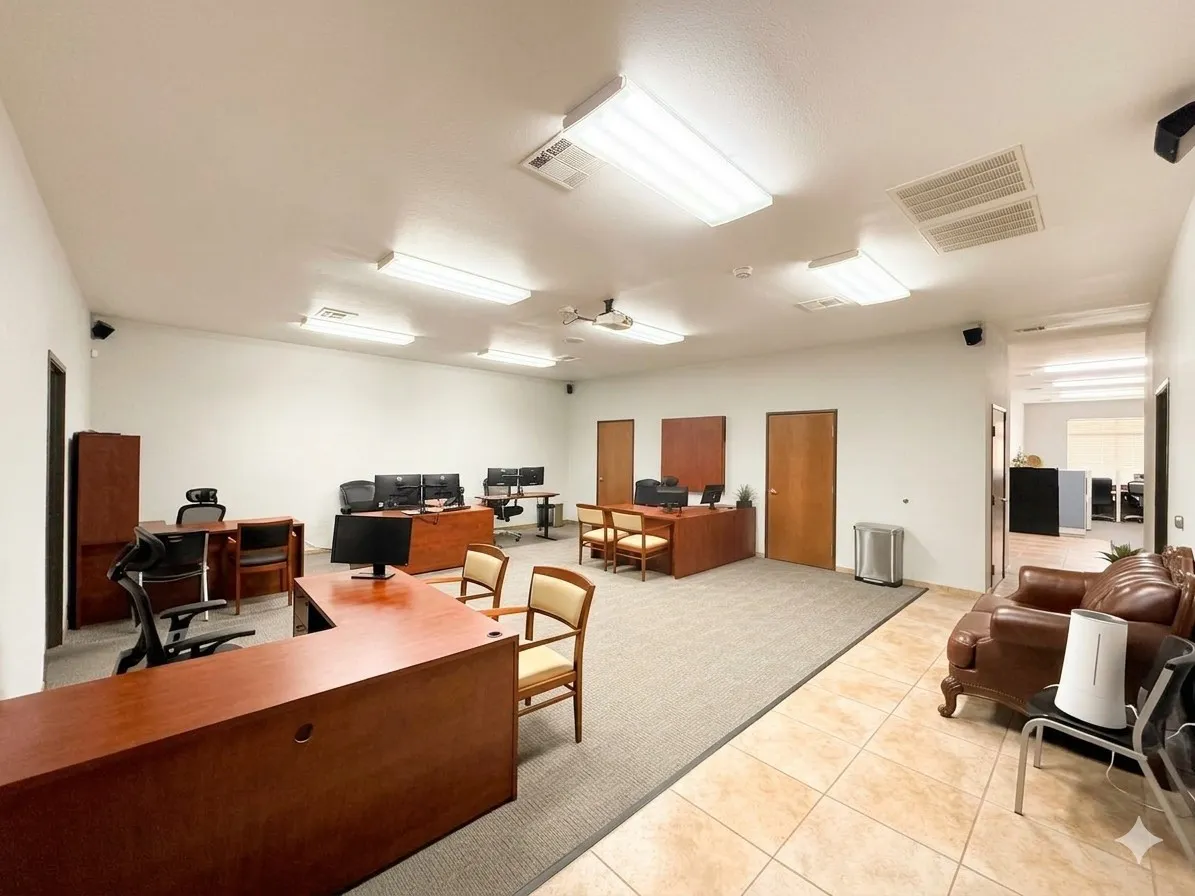 Spacious open-concept commercial interior featuring recessed lighting, projector, multiple private offices, tile flooring, and carpeted work areas