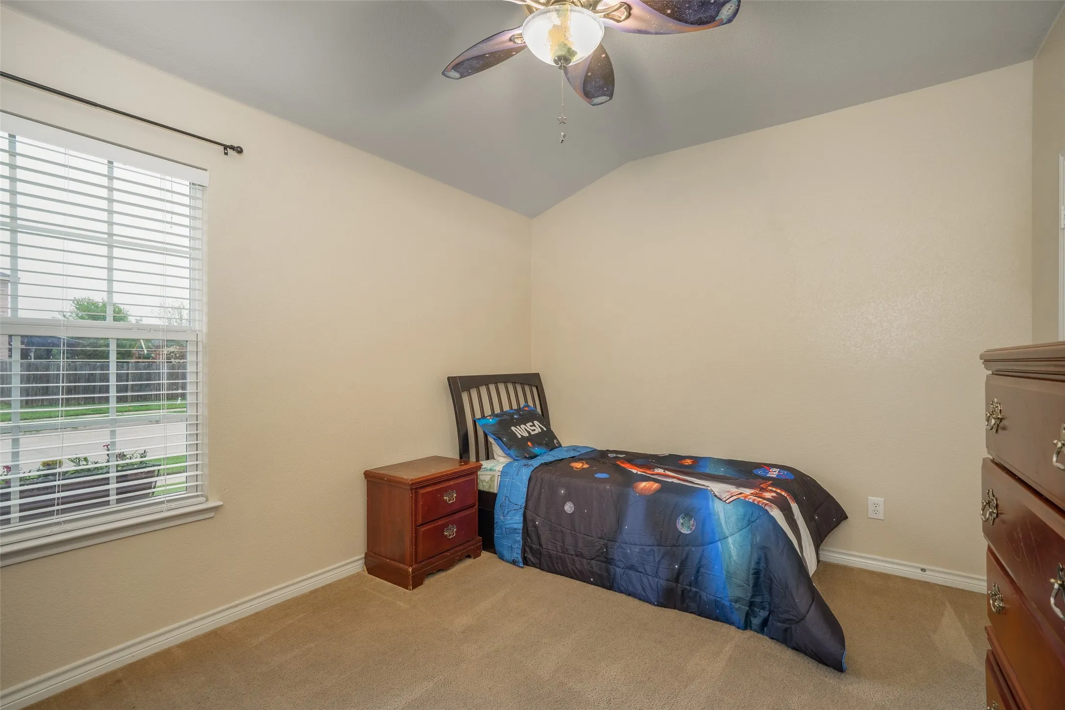 Carpeted room featuring a window with blinds, a ceiling fan, and sloped ceiling