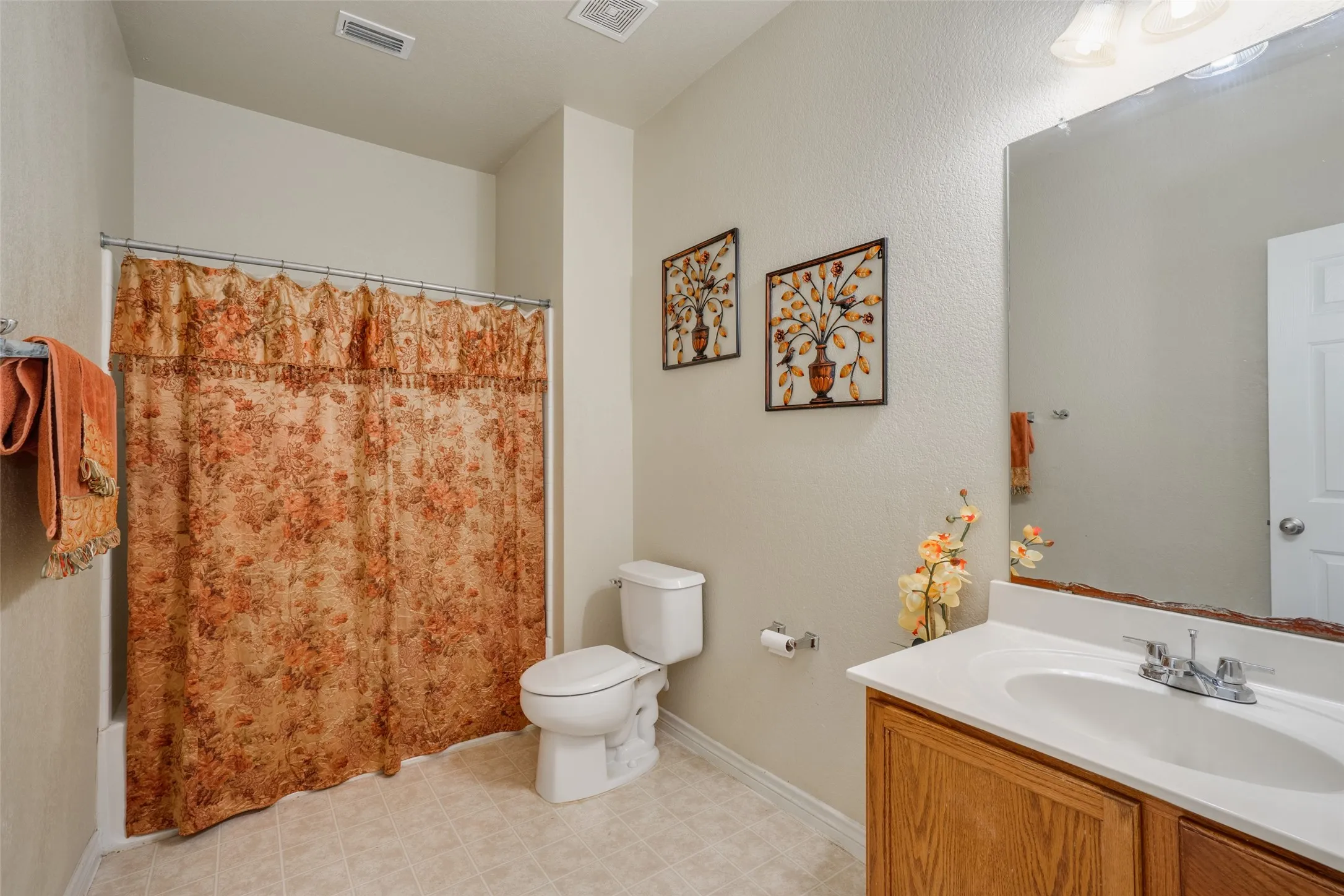 Bathroom with a white vanity sink, wood-finish cabinetry, and an integrated bathtub