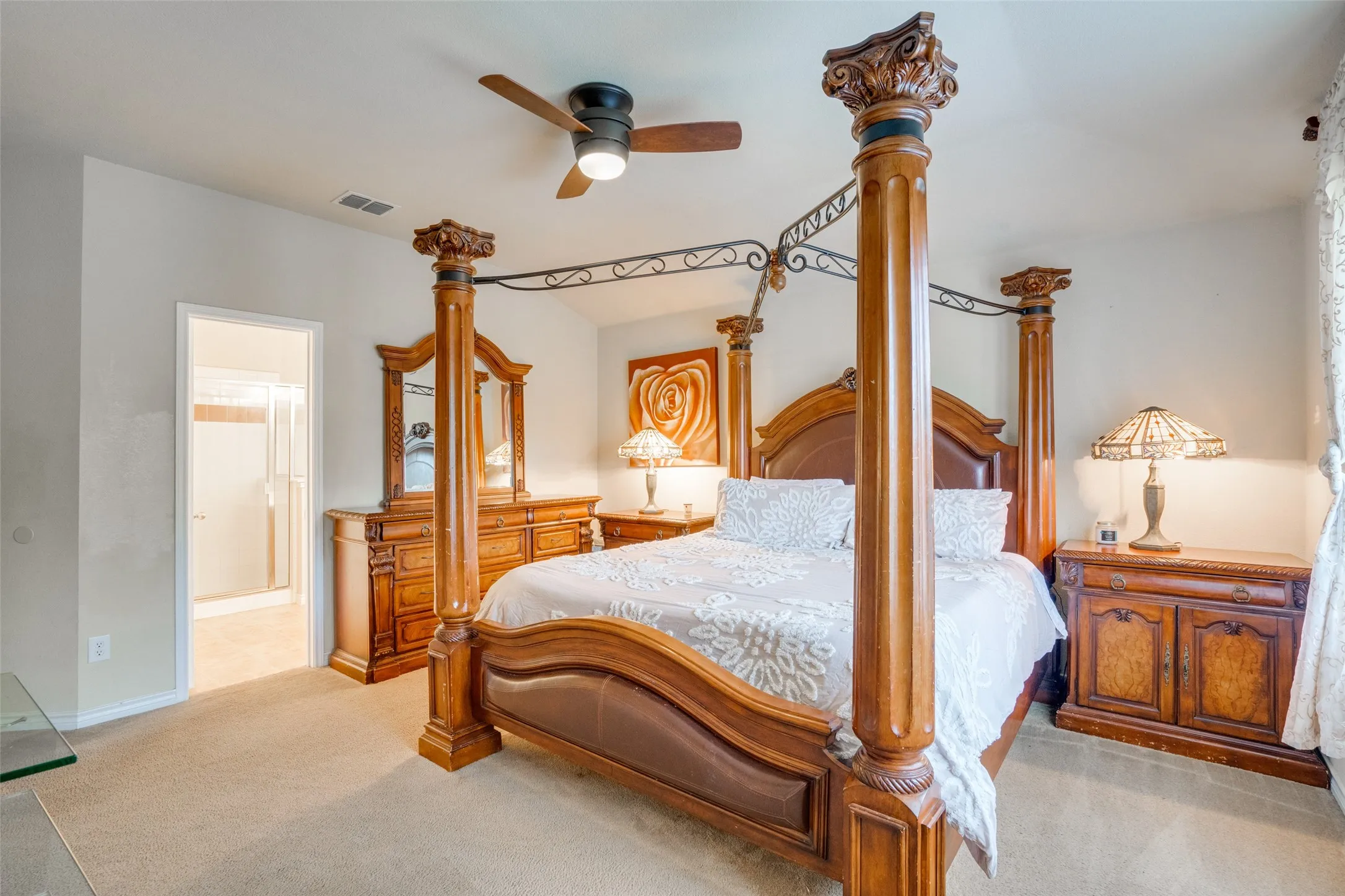 Carpeted bedroom featuring a ceiling fan, coved ceiling, and an open doorway to a bathroom with a glass-enclosed shower