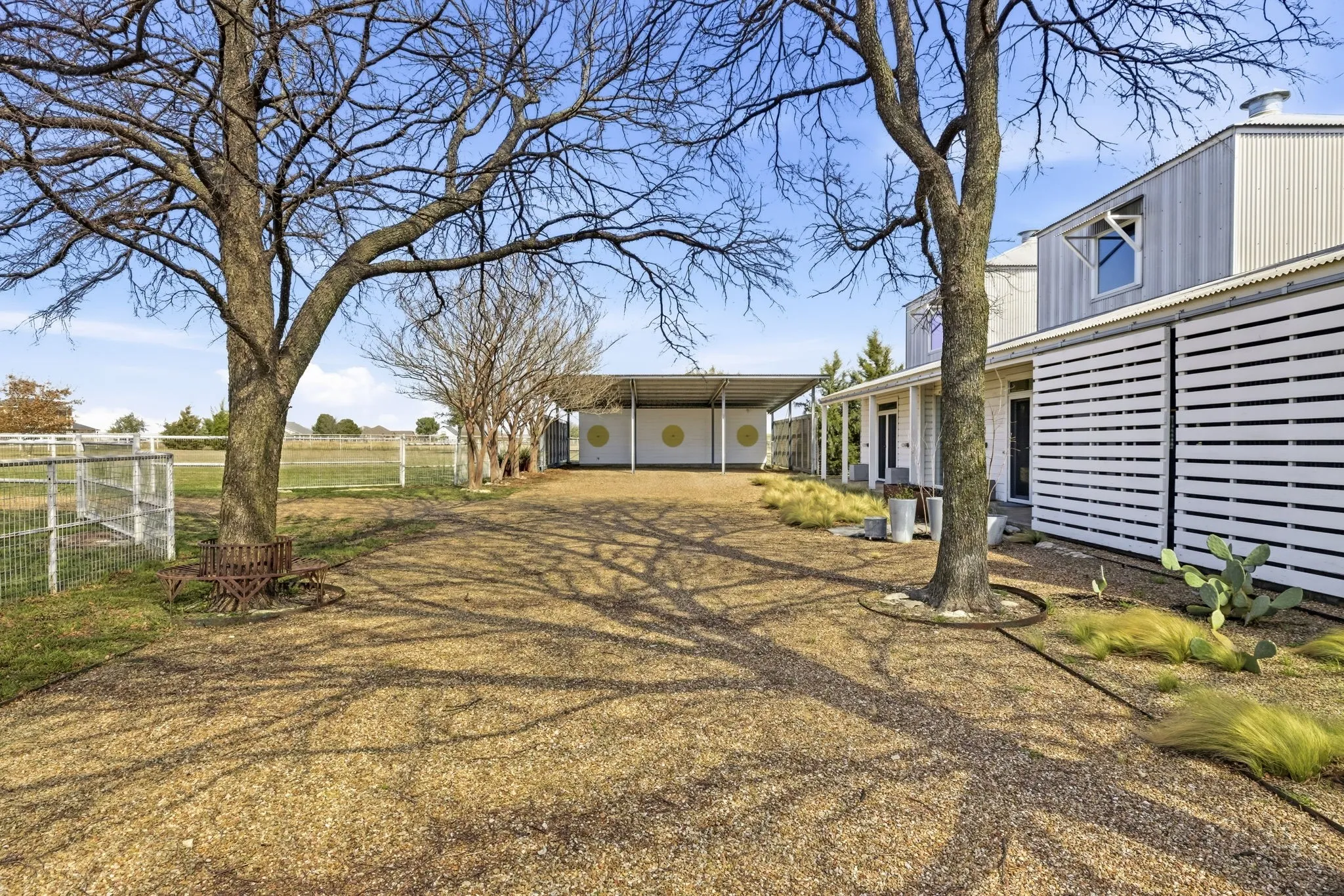 Gravel driveway leading to the three-car carport