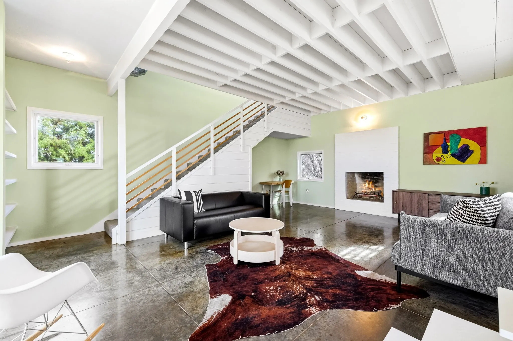 Living area featuring a wood burning brick fireplace and stained concrete flooring