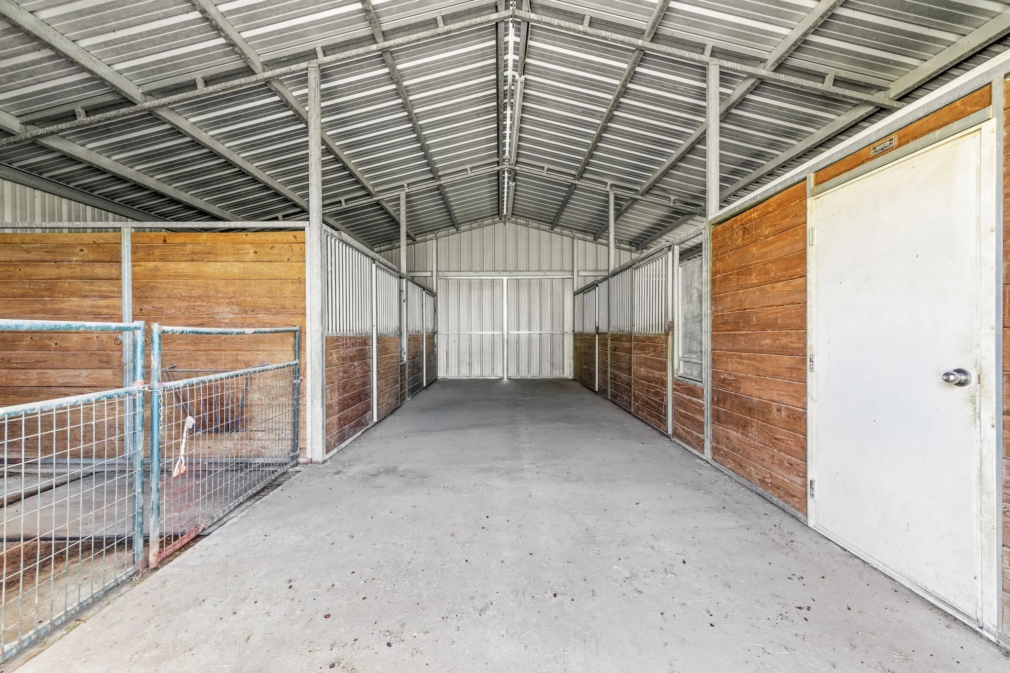Four-stall barn includes a tack room, wash bay, electrical, and lighting.