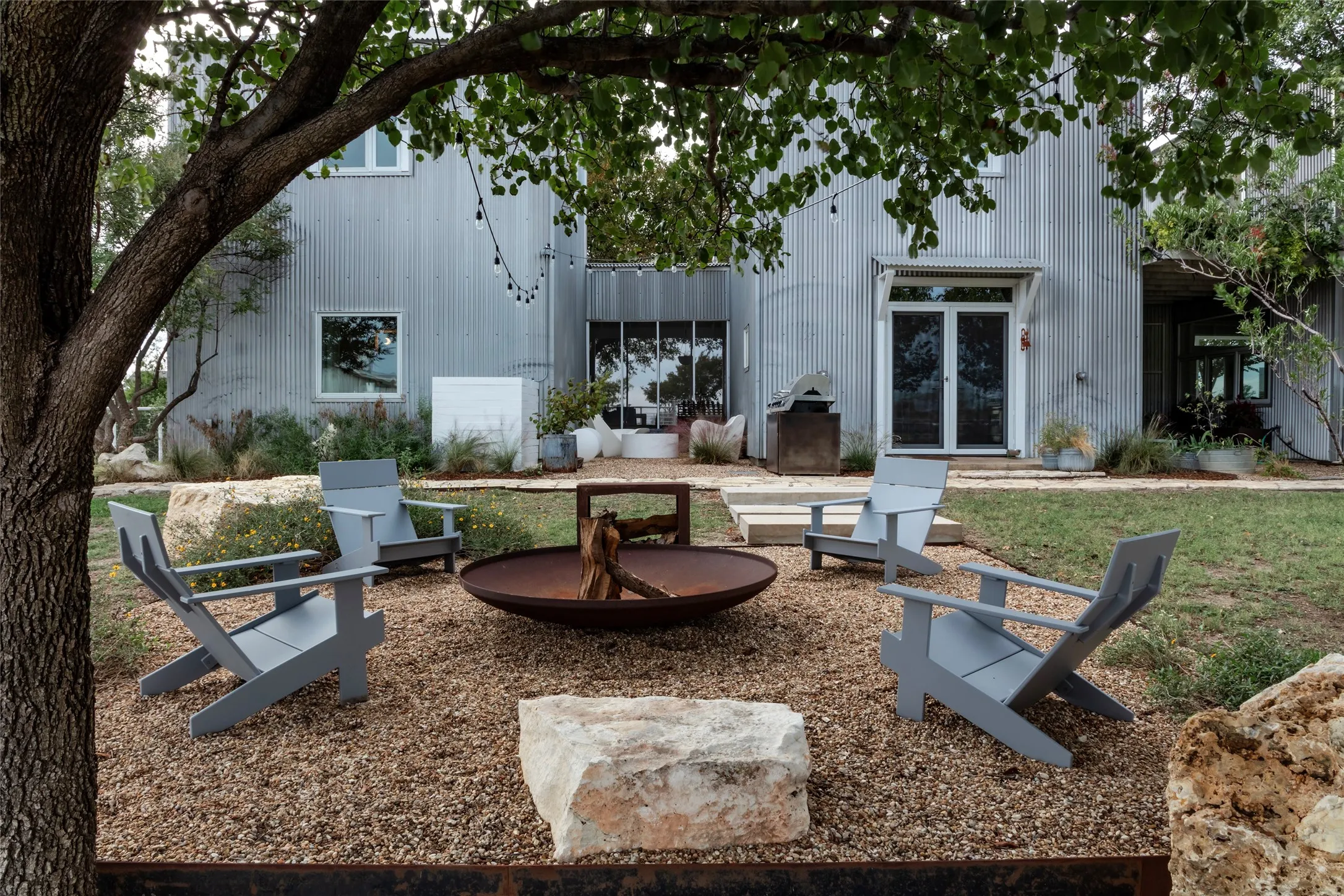 Fenced backyard featuring multiple seating areas and a fire pit.