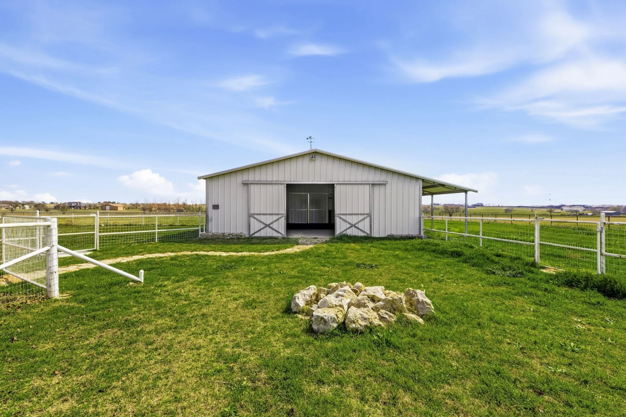 Four-stall barn includes a tack room, wash bay, electrical, and lighting.