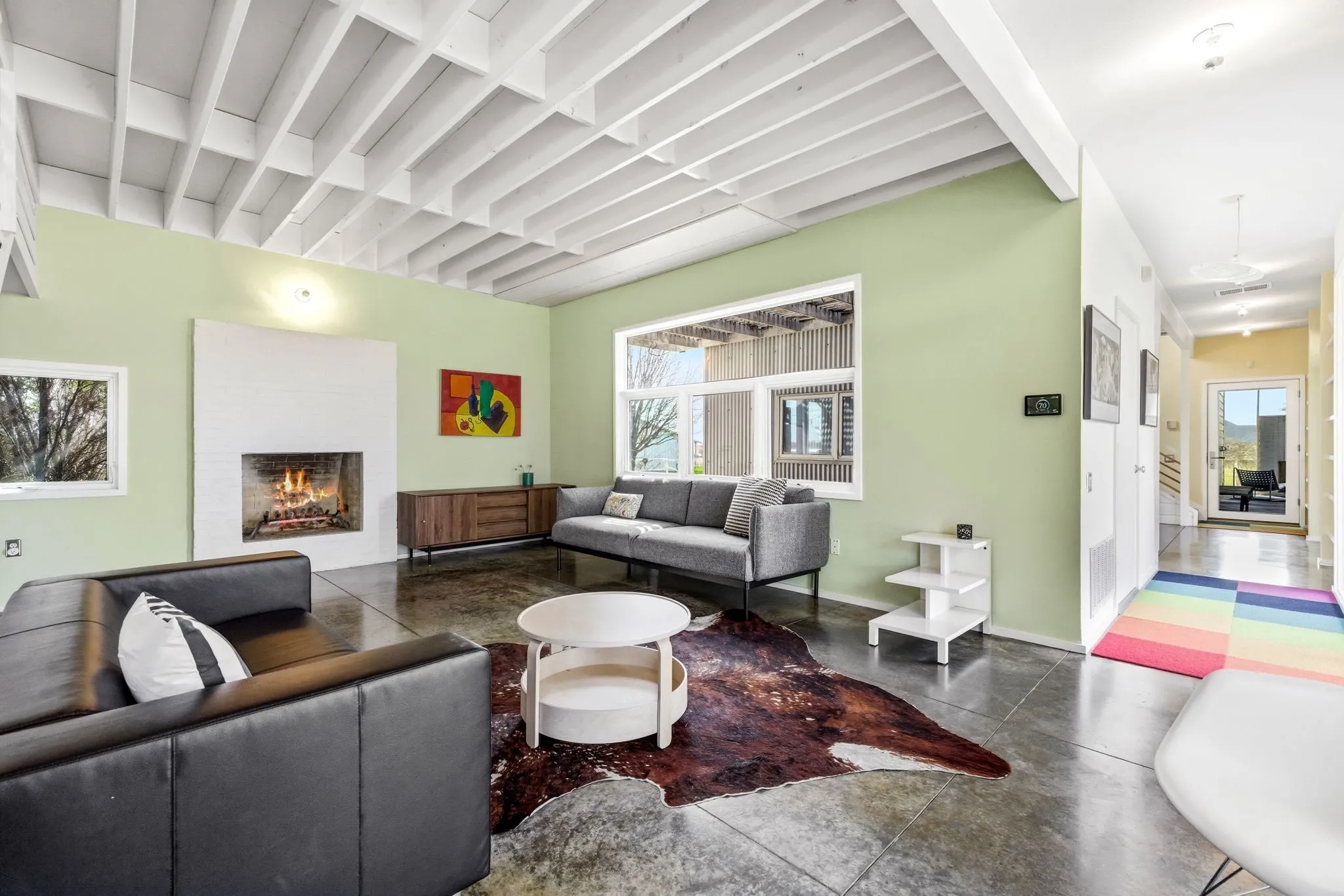 Living area featuring a wood burning brick fireplace and stained concrete flooring