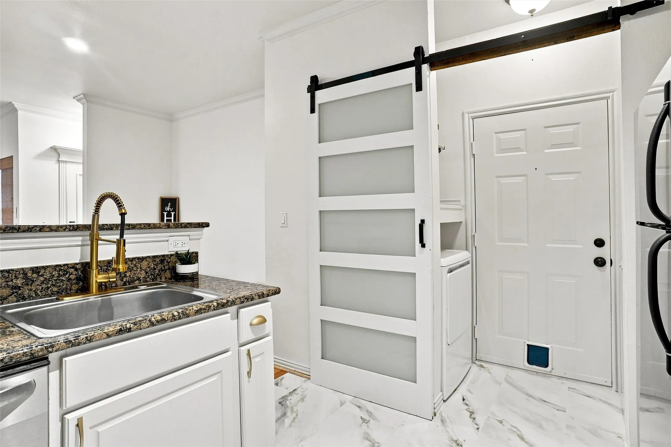 Kitchen sink with gold-finish gooseneck faucet and granite-look countertop