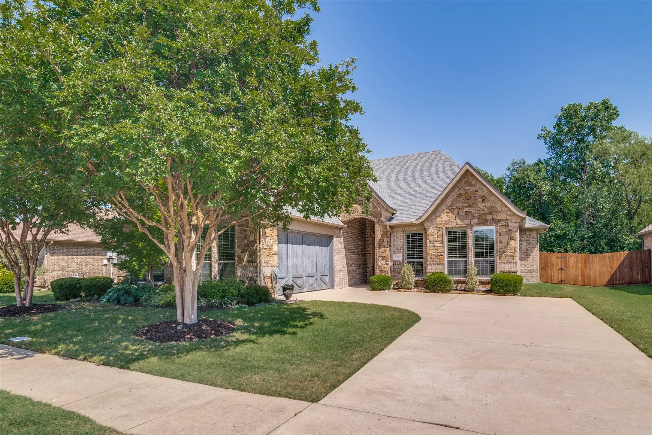 Front yard nicely landscaped with mature tree