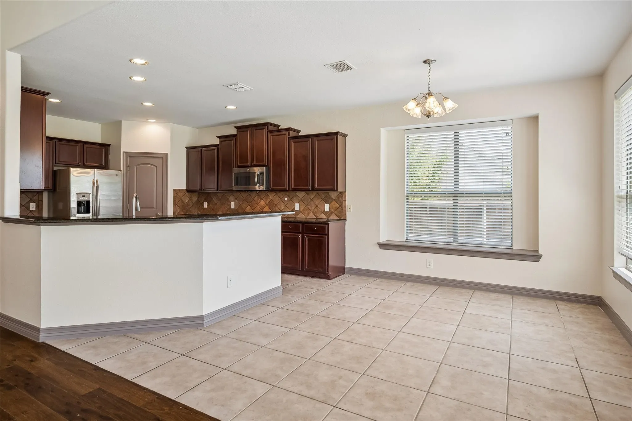 Kitchen featuring dark wood cabinetry, stainless steel appliances, and a tiled backsplash