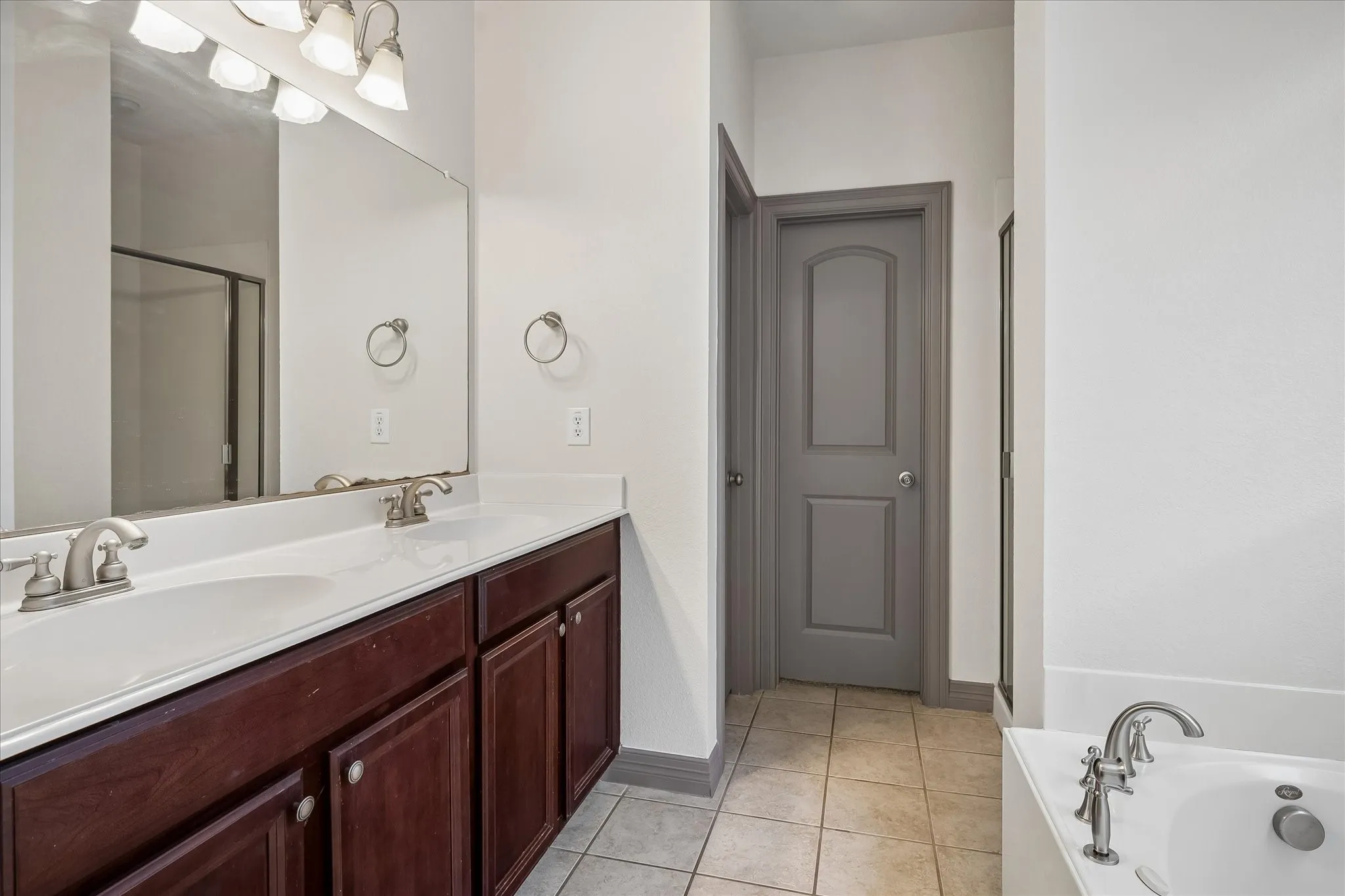 Dual vanity with under-mount sinks, a large mirror, and brushed nickel fixtures