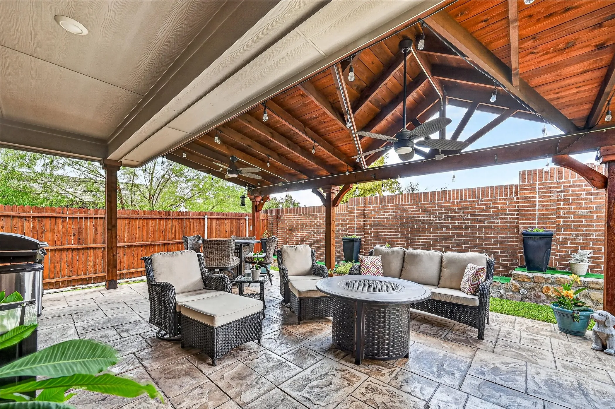 Expansive covered patio featuring stamped concrete flooring, a wood-paneled ceiling, and ceiling fans
