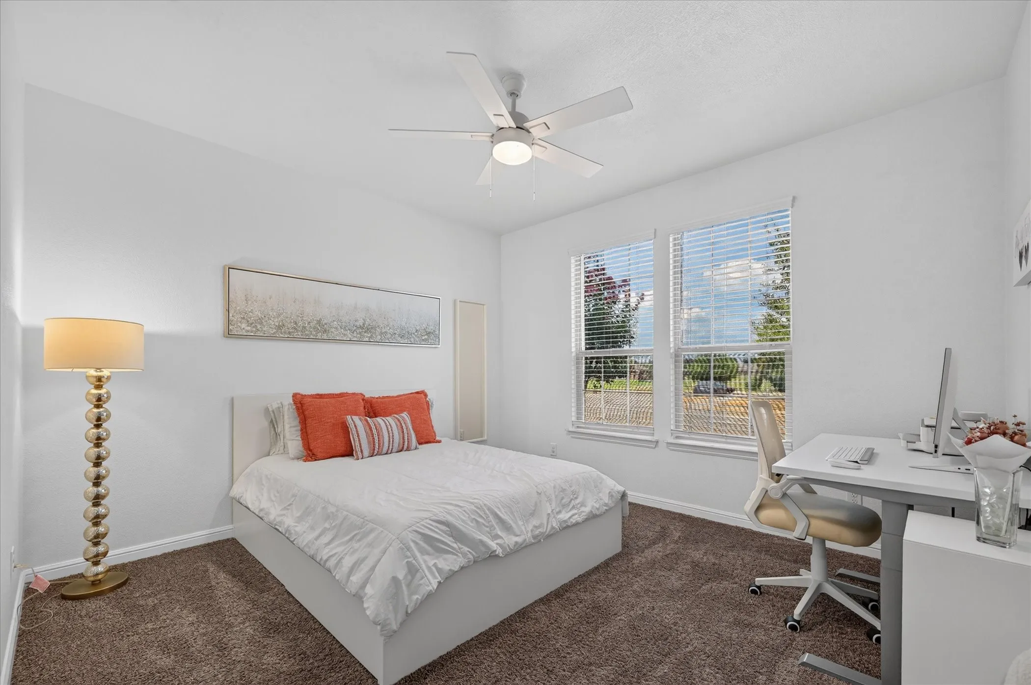 Room featuring two windows with blinds, a ceiling fan, and carpet flooring
