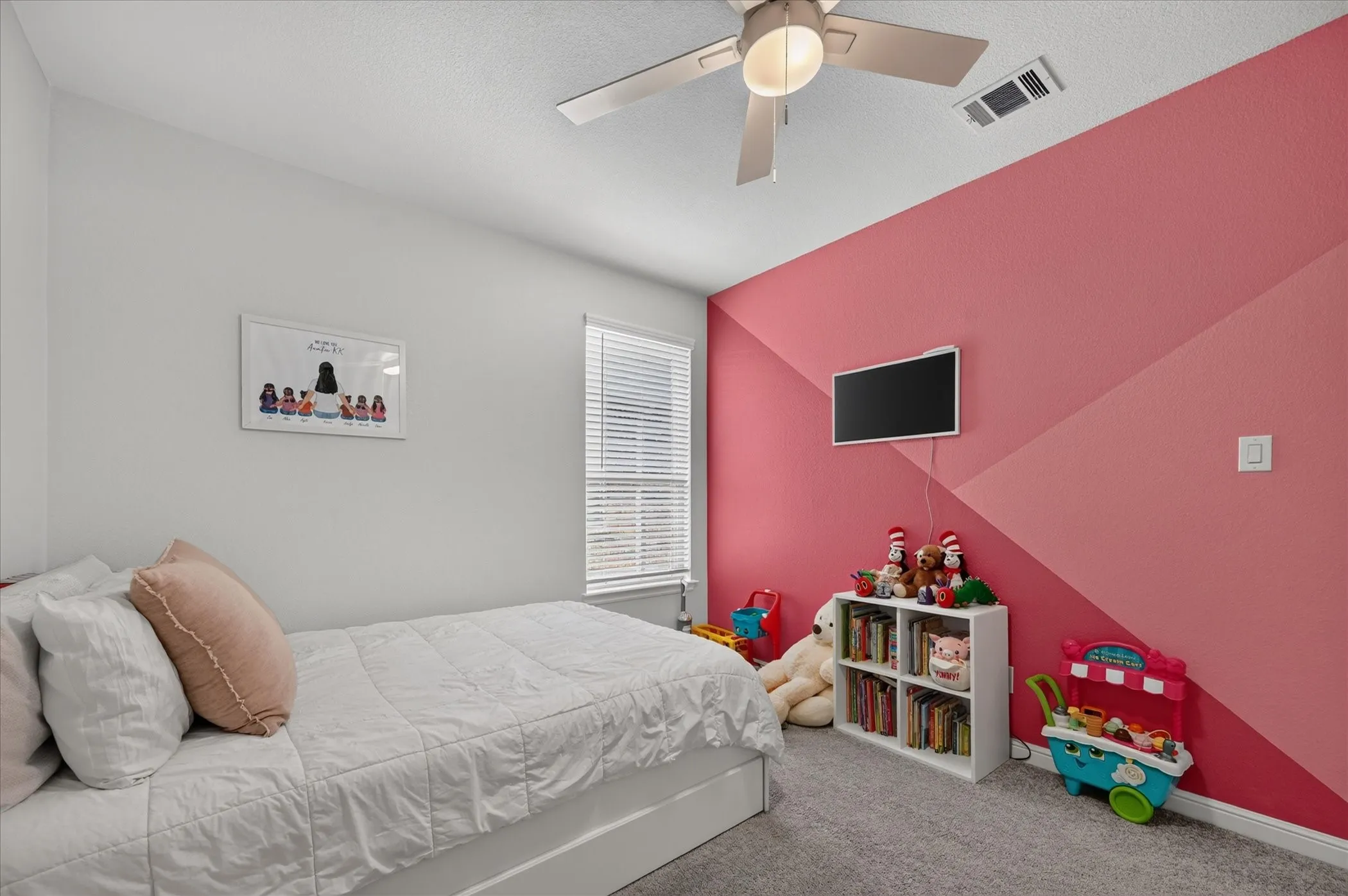 Wall-mounted television with visible wiring, ceiling fan with integrated lighting, window with blinds, and white built-in shelving