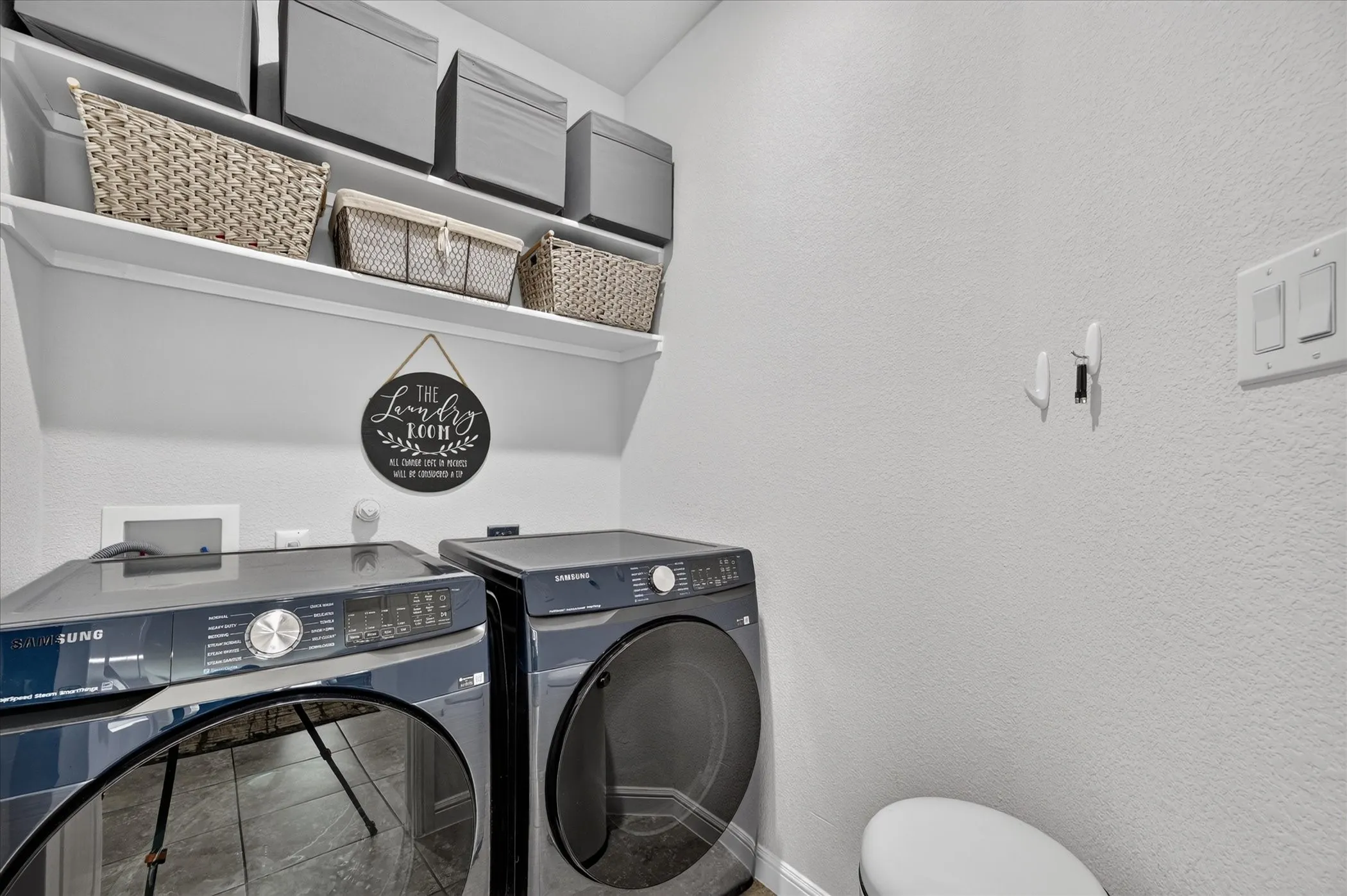 Laundry area with built-in shelving and tile flooring