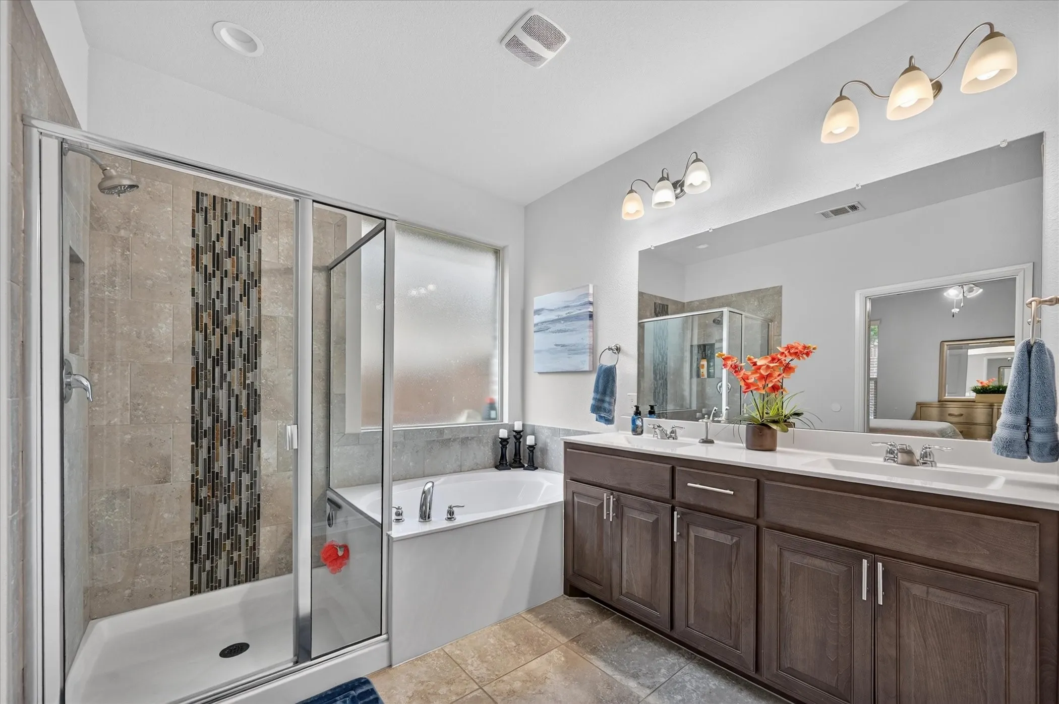 Dual vanity with undermount sinks, bronze finish hardware, and a large mirror
