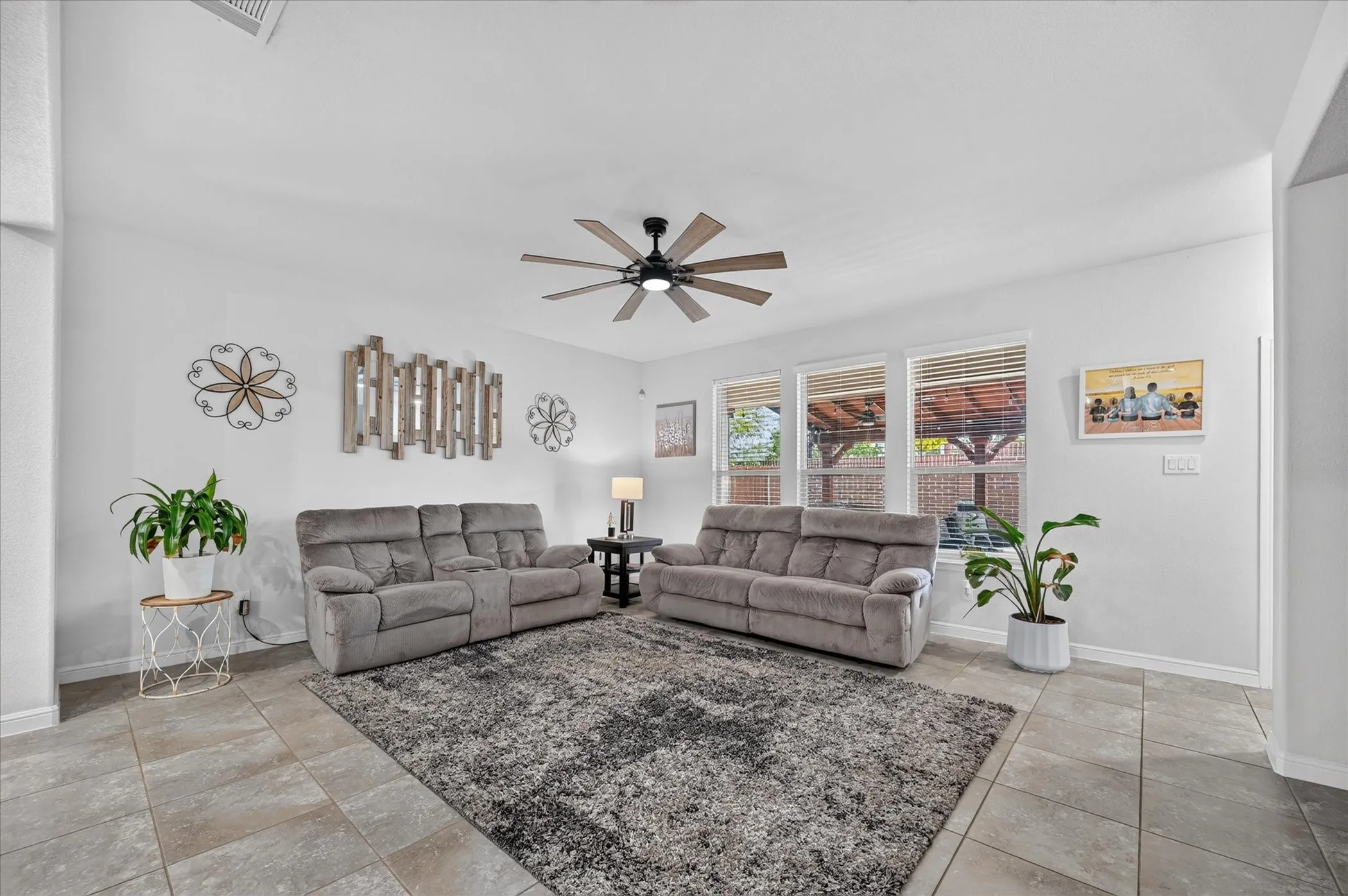 Vaulted ceilings, a dark wood-finish ceiling fan, and tile flooring