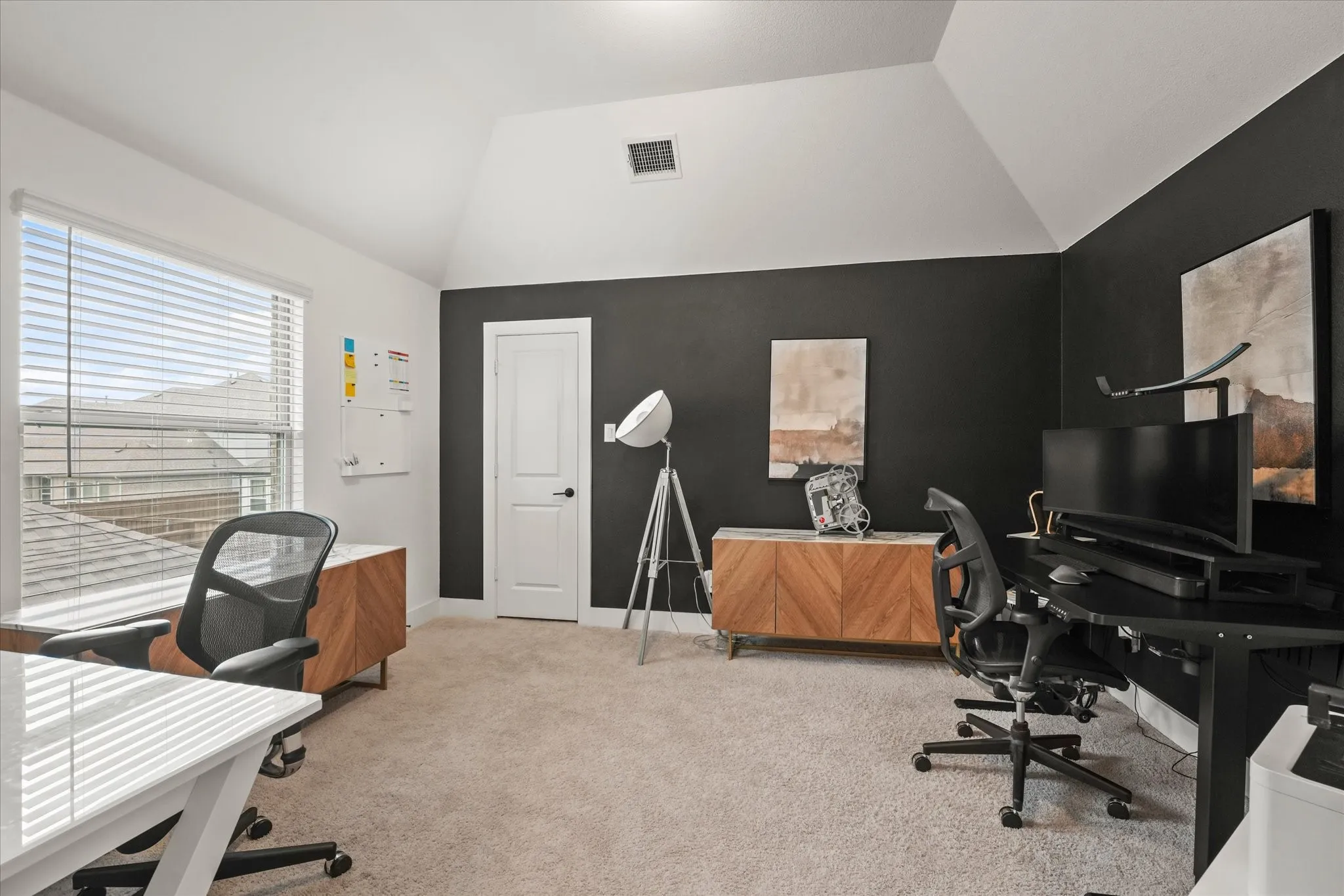 Vaulted ceiling room with carpet flooring and a window featuring horizontal blinds