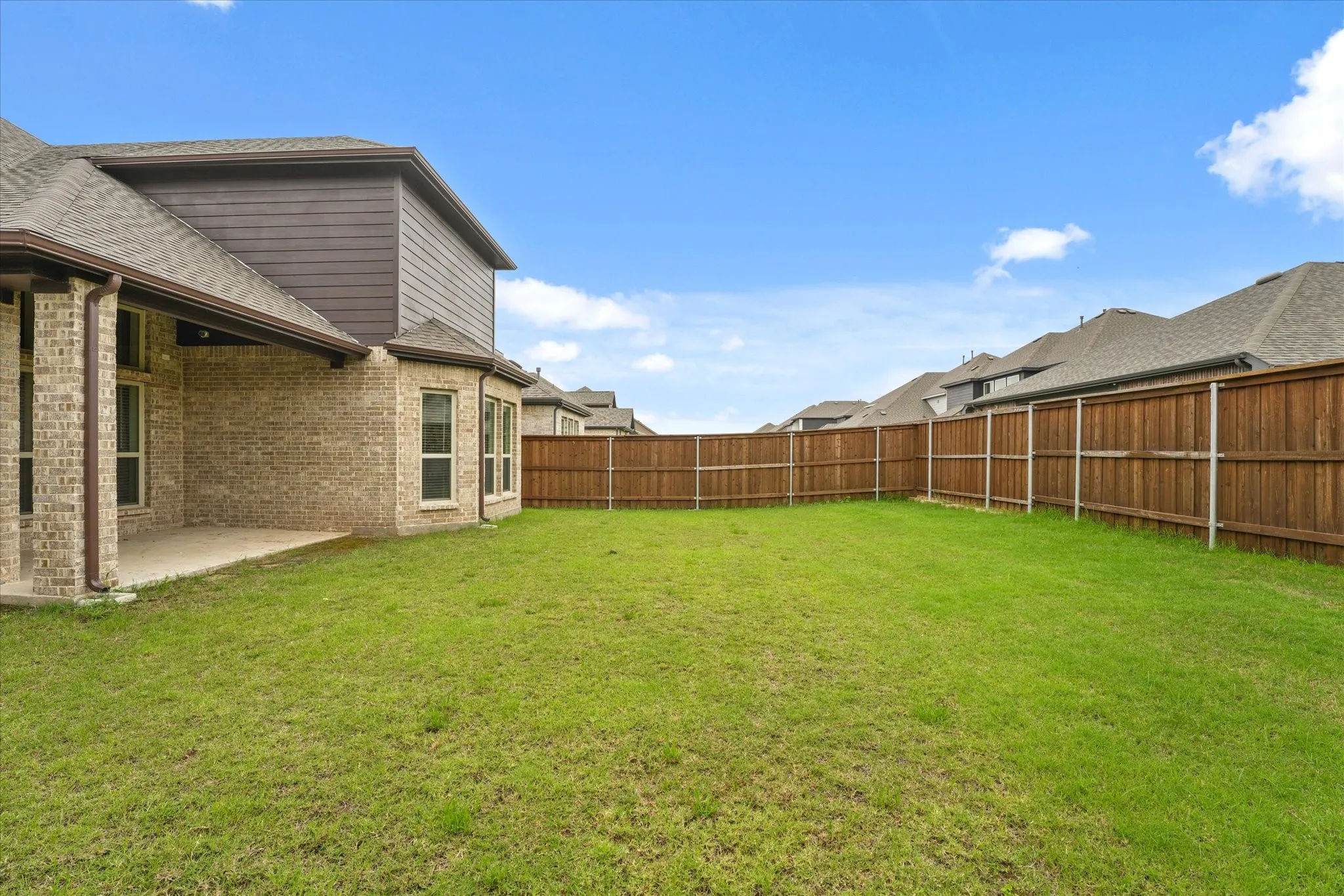 Expansive backyard featuring a wood privacy fence and a concrete patio