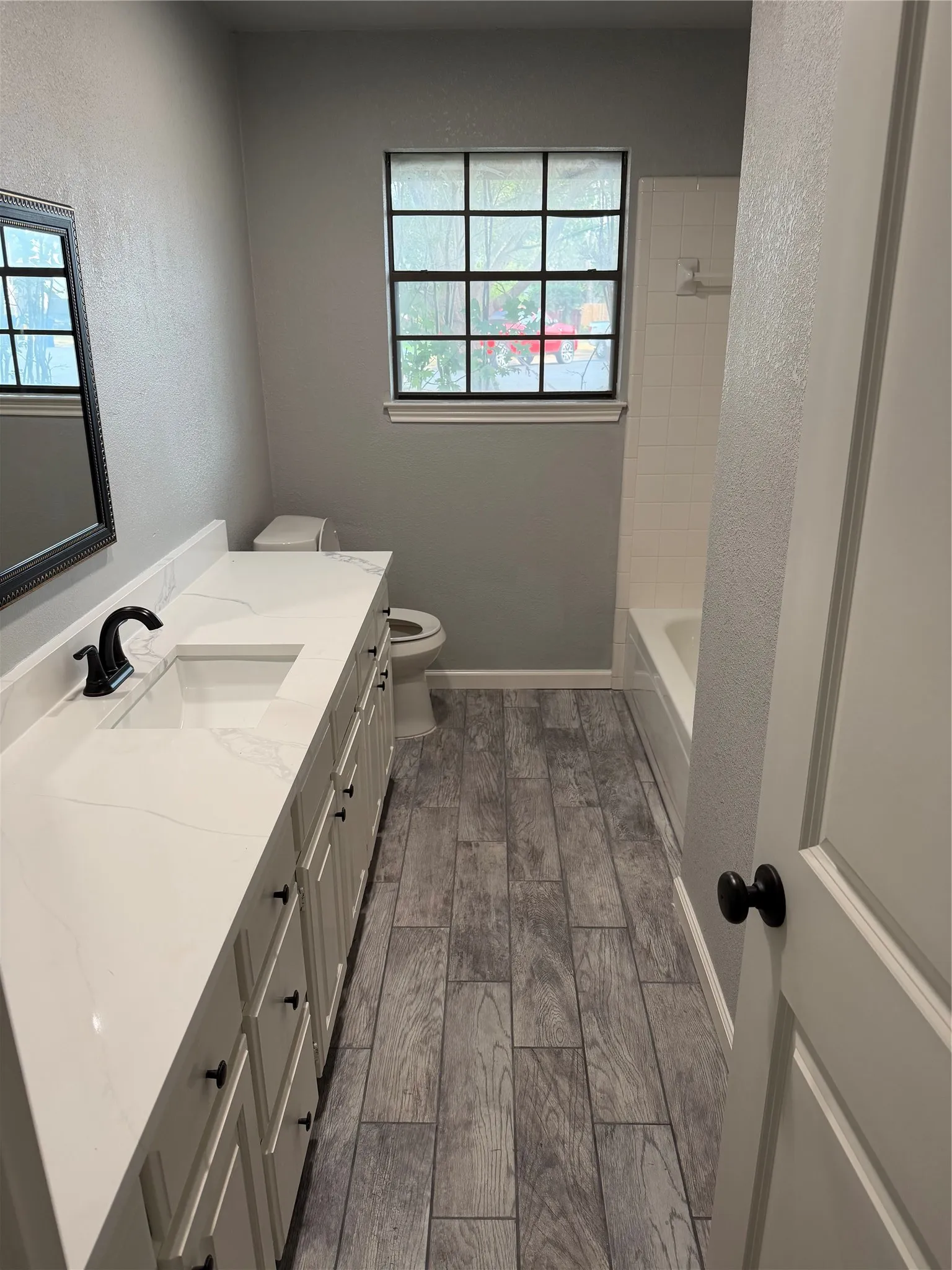 Long vanity with dual undermount sinks, quartz-finish countertop, and black fixtures