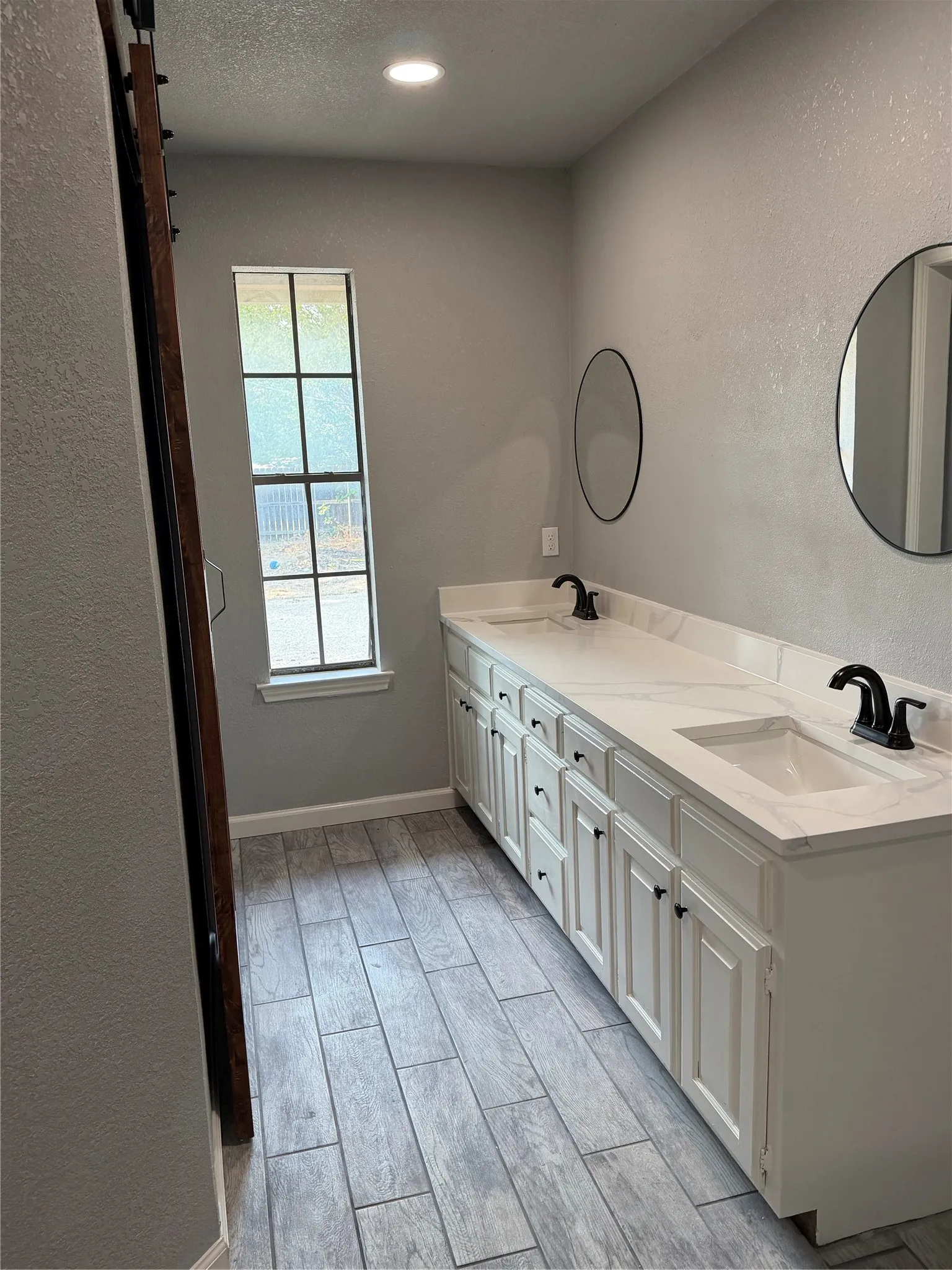 Double vanity with integrated sinks, black fixtures, and white cabinetry