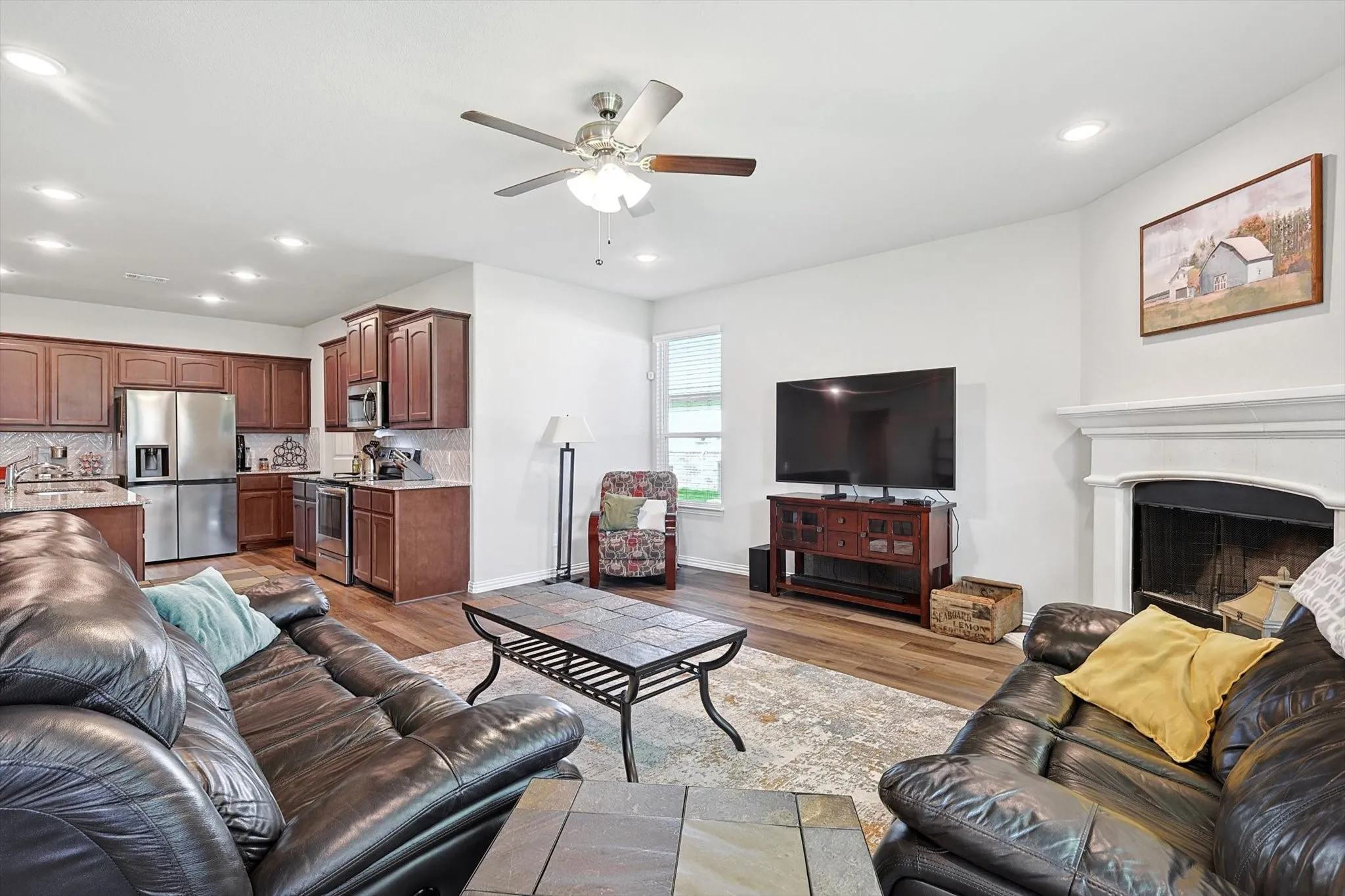 Living area with a fireplace, recessed lighting, and a ceiling fan