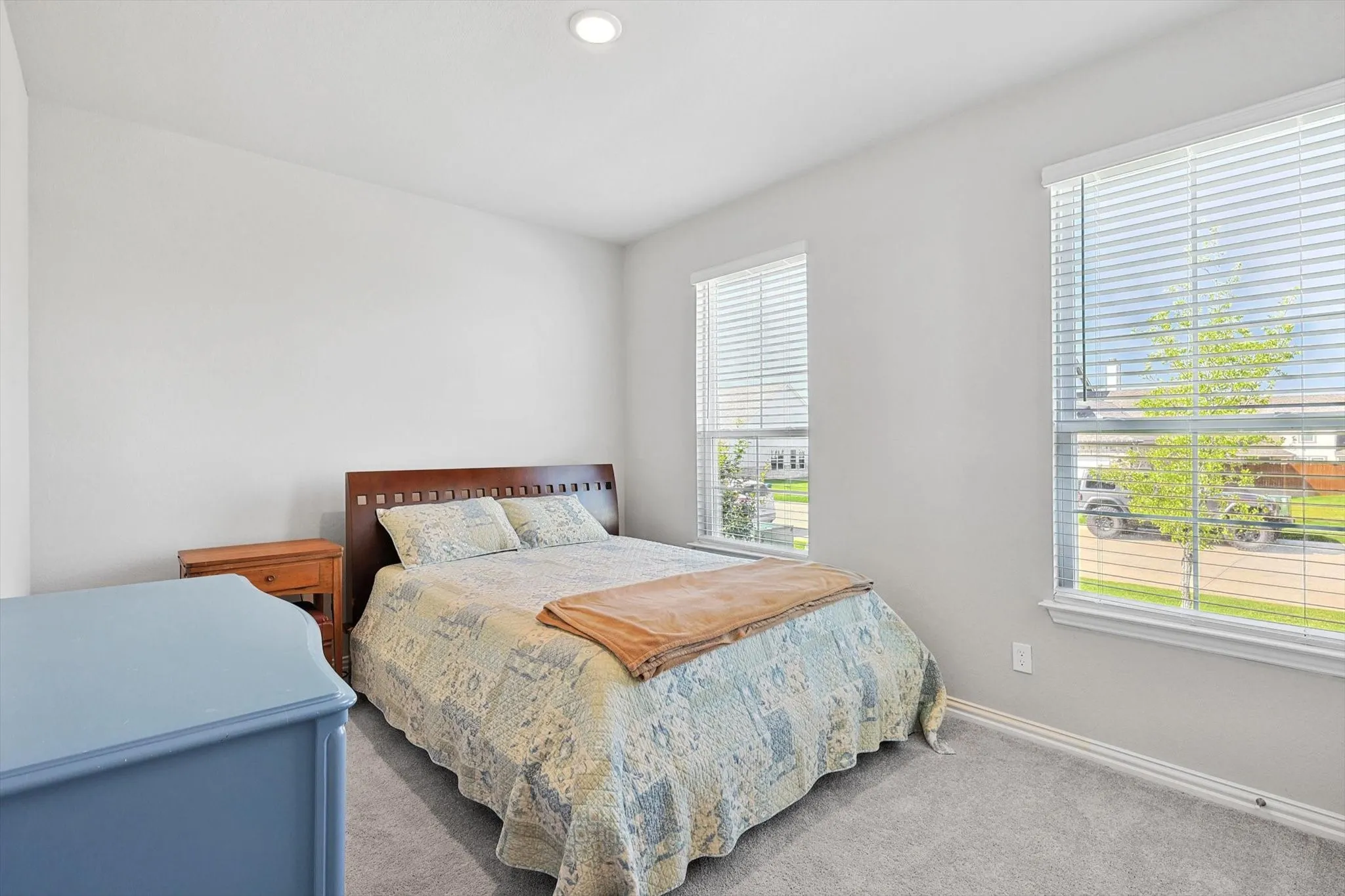Recessed ceiling lighting, two windows with blinds, light gray wall paint, and gray carpet flooring